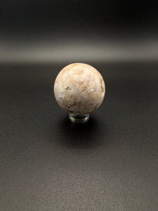 Flower agate polished crystal in the shape of a sphere.