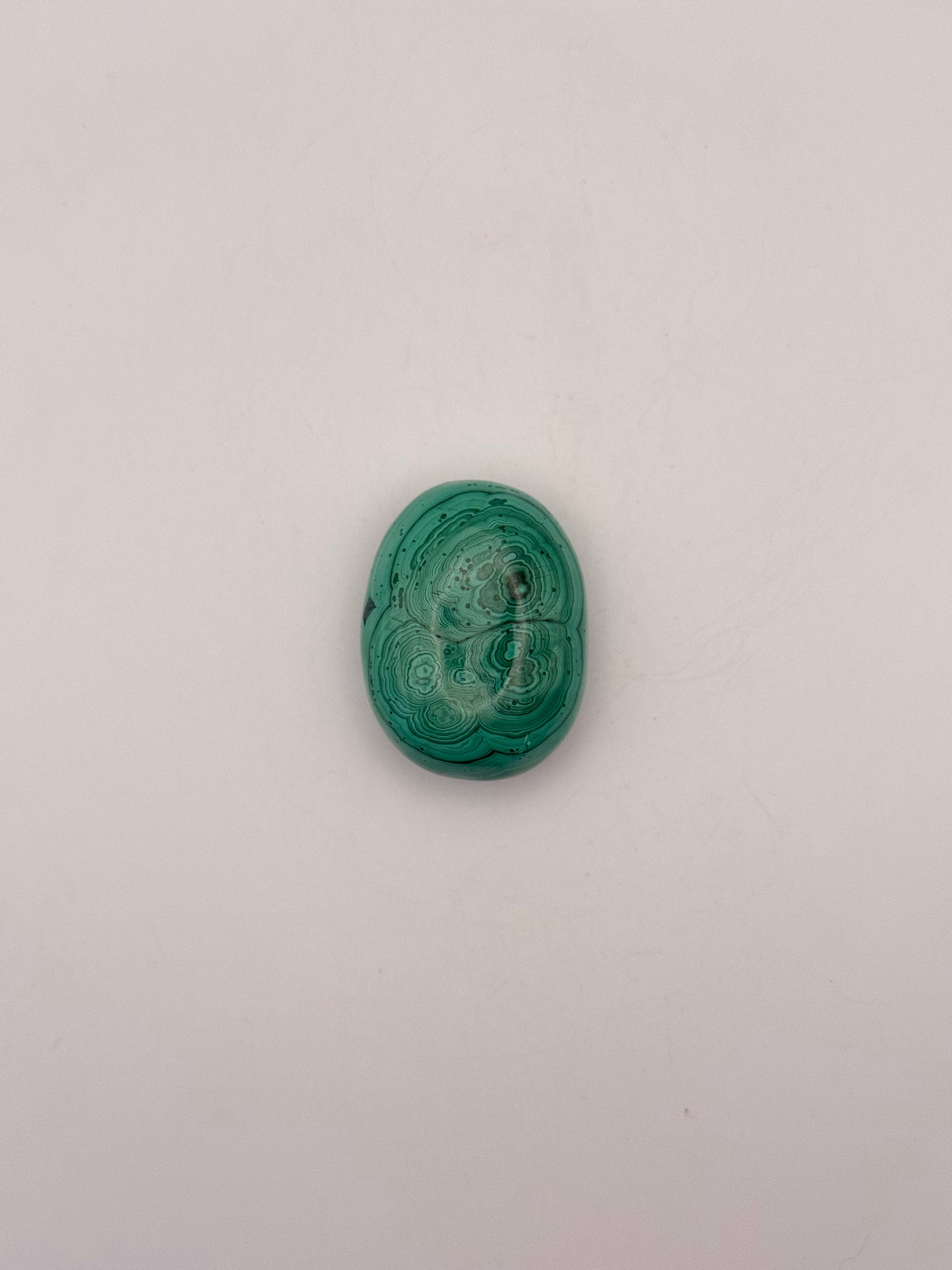 Vibrant green malachite palm stone with unique swirling patterns.