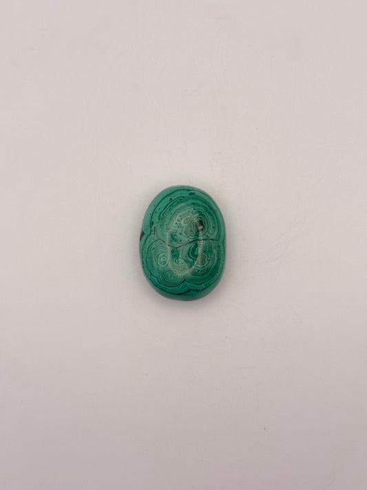 Vibrant green malachite palm stone with unique swirling patterns.