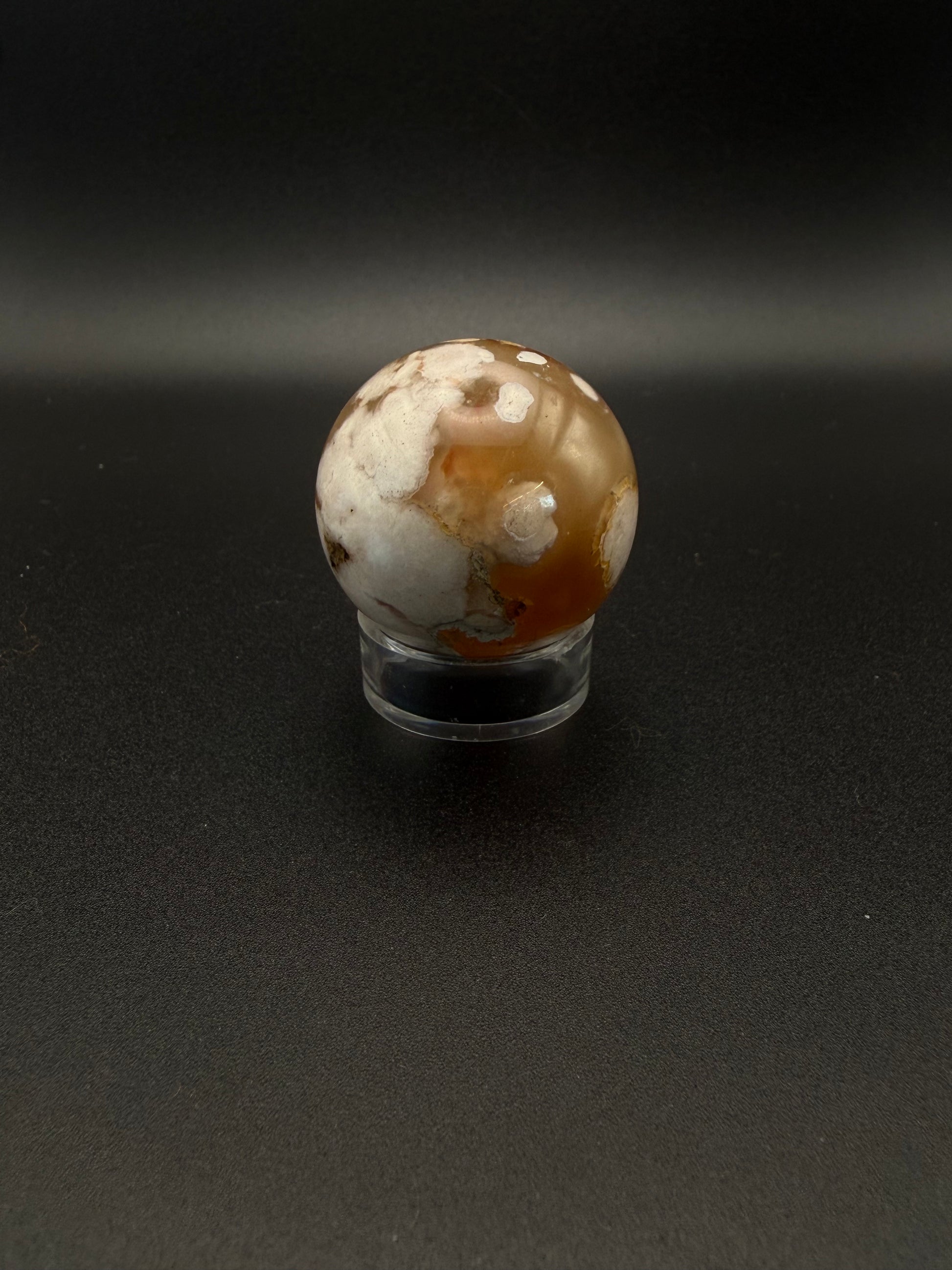 Flower agate polished crystal in the shape of a sphere.
