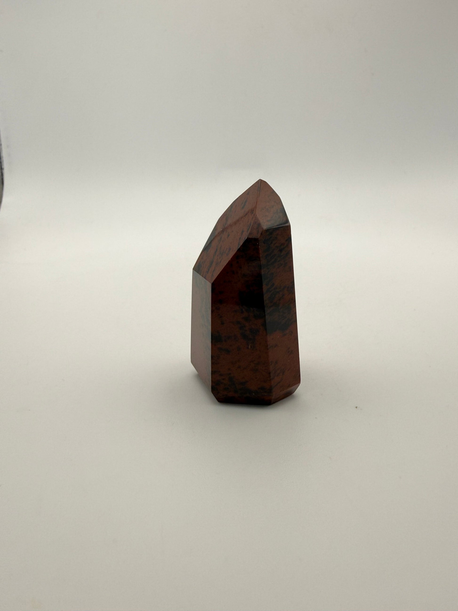 Polished mahogany obsidian tower with six sides.