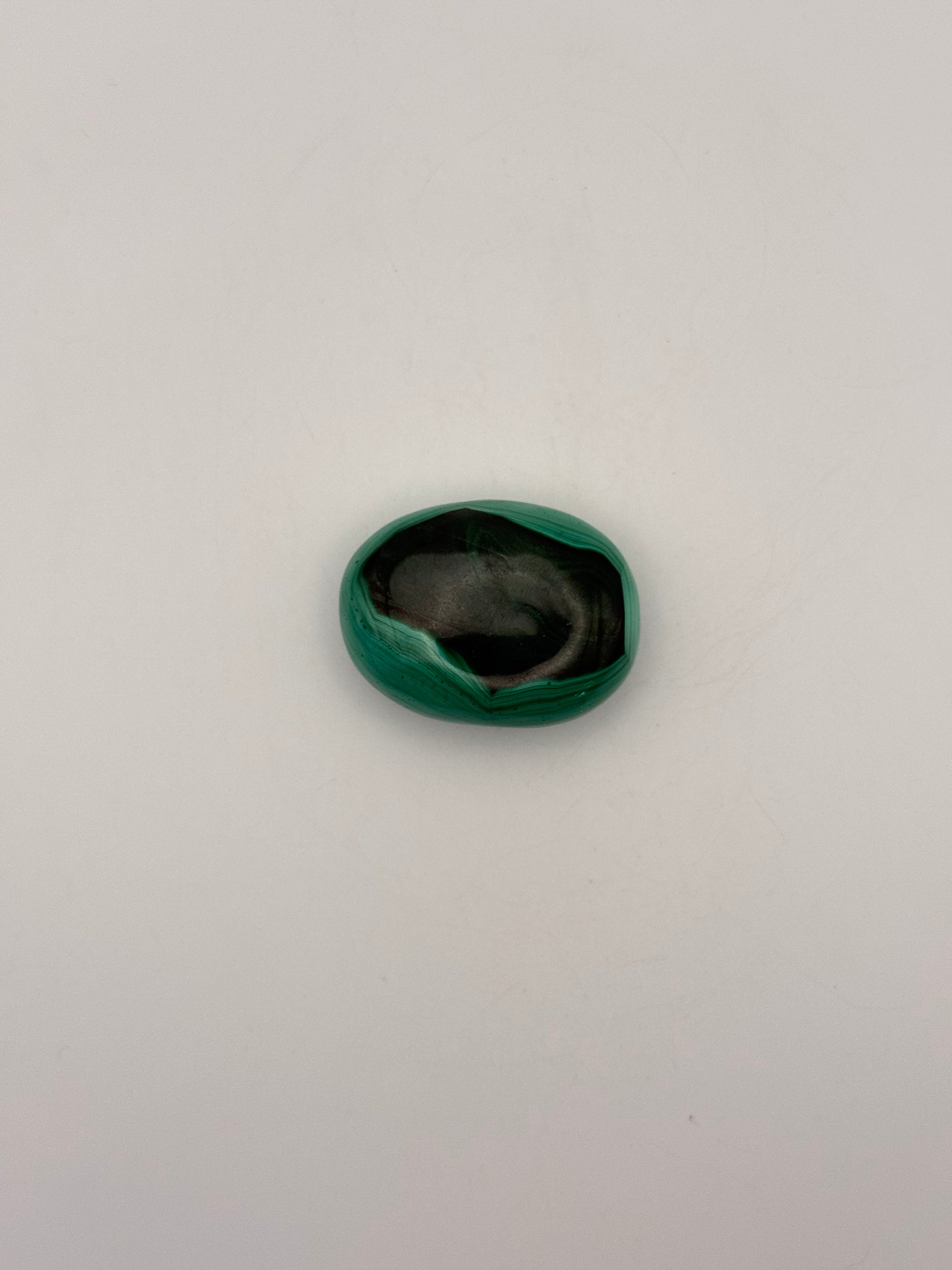 Vibrant green malachite palm stone with unique swirling patterns.