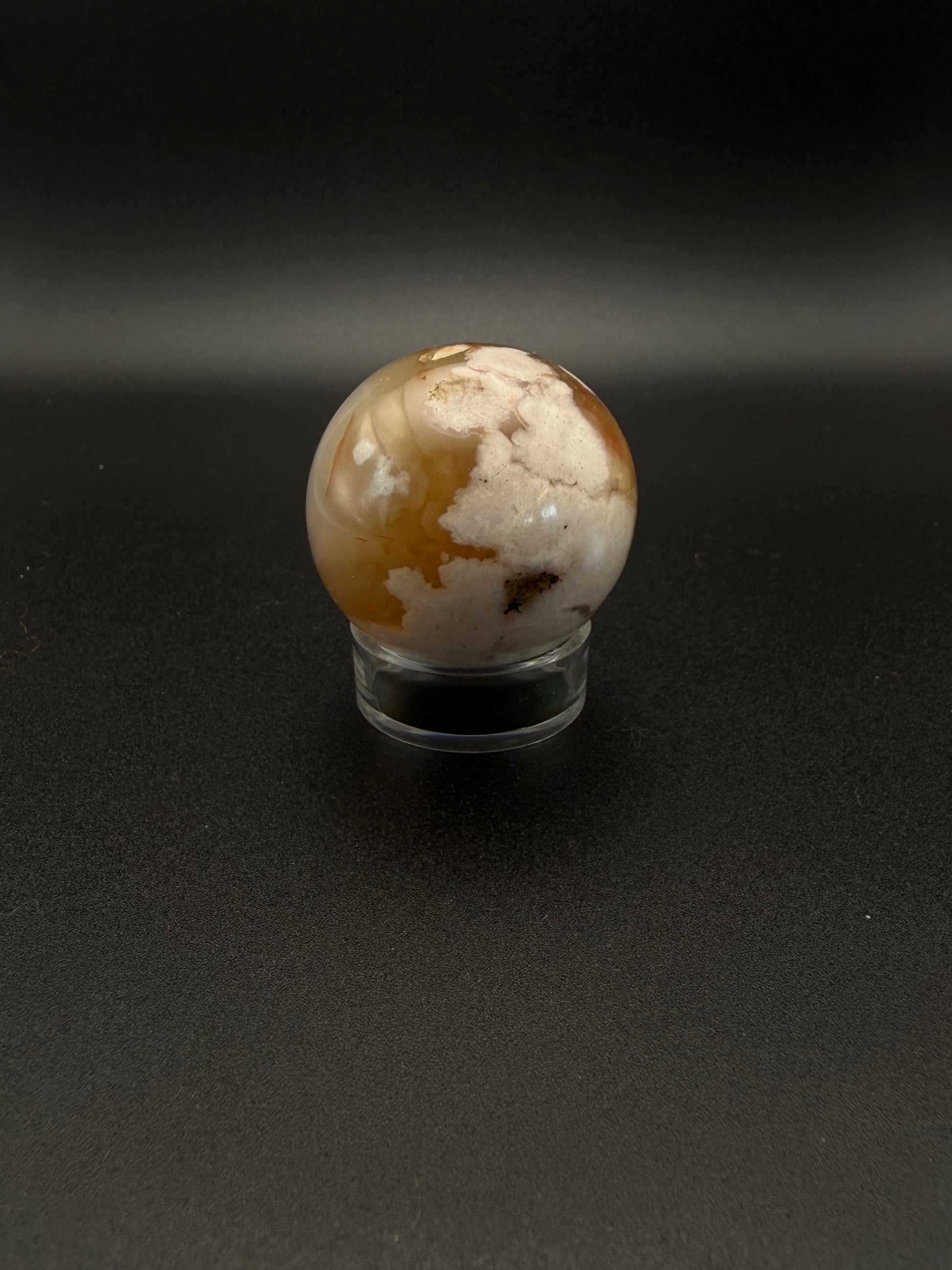 Flower agate polished crystal in the shape of a sphere.