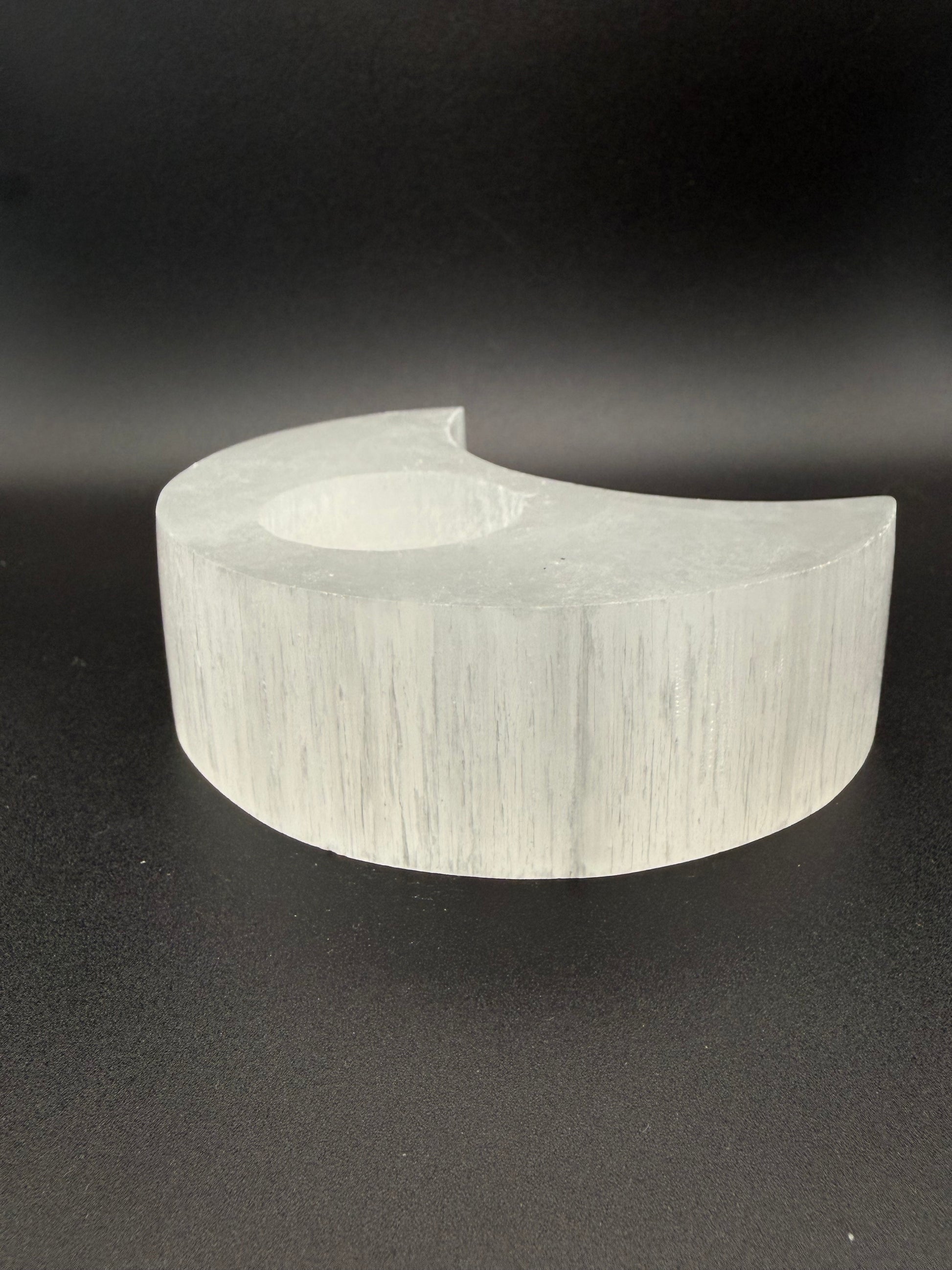Selenite candle holder in the shape of a moon.