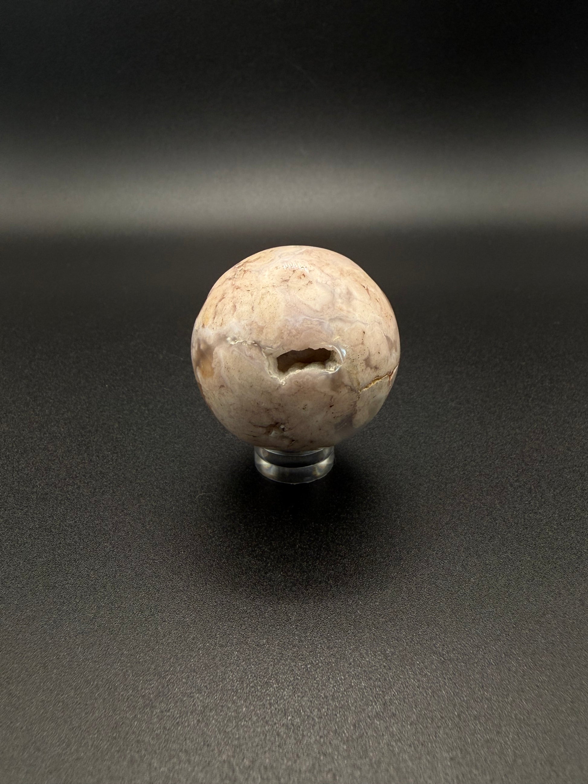 Flower agate polished crystal in the shape of a sphere.