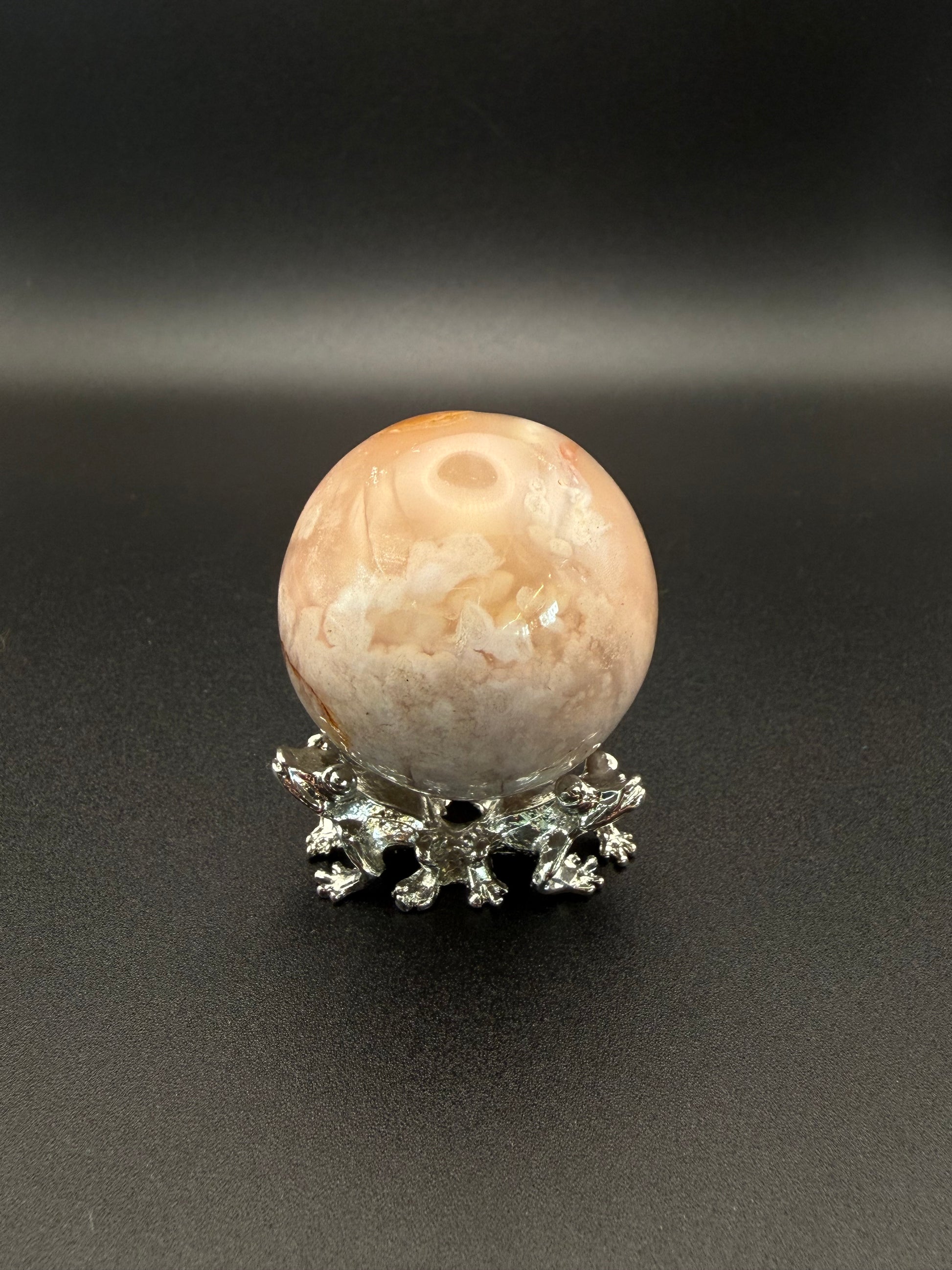 Flower agate polished crystal in the shape of a sphere.