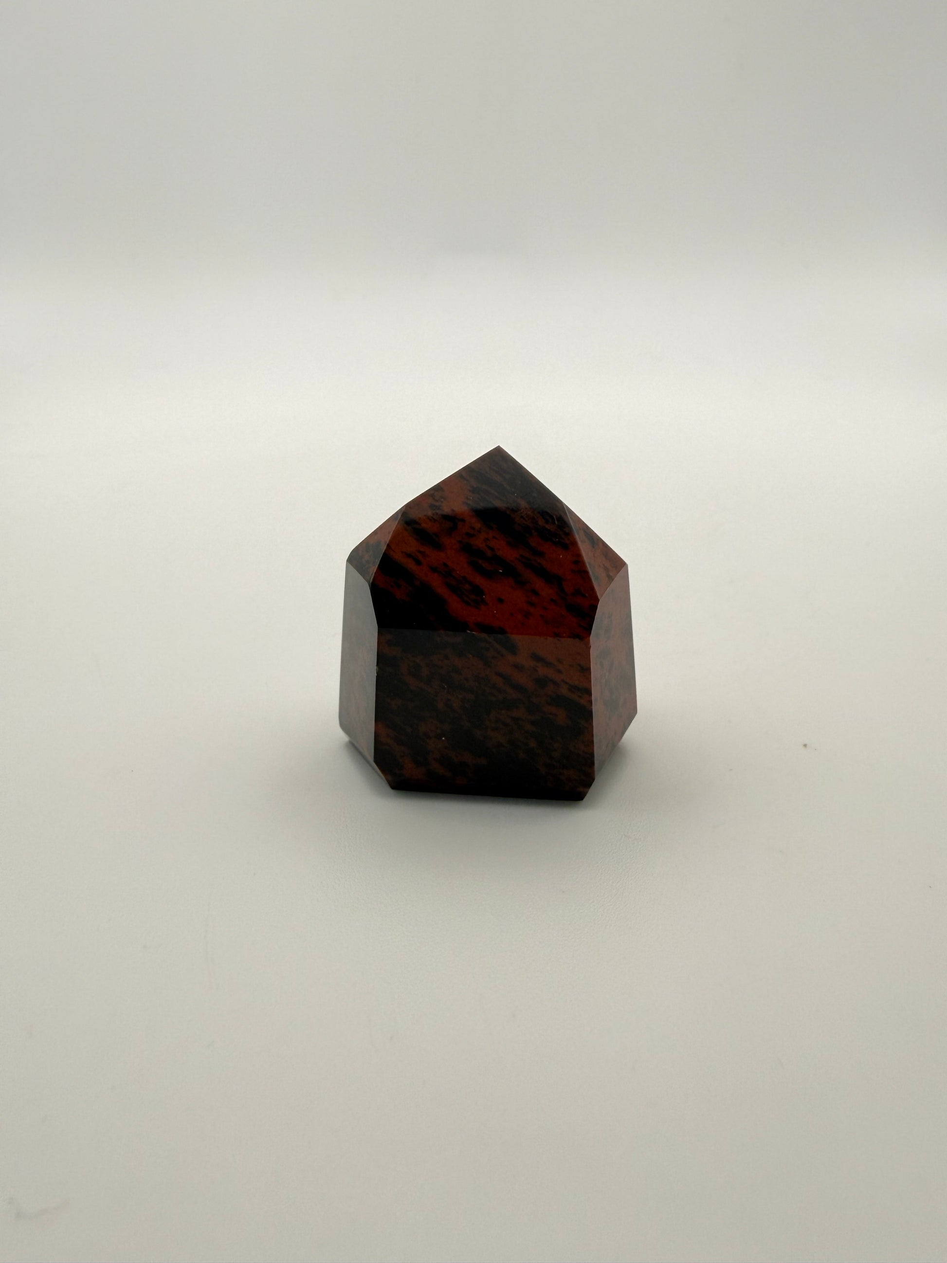 Polished mahogany obsidian tower with six sides.