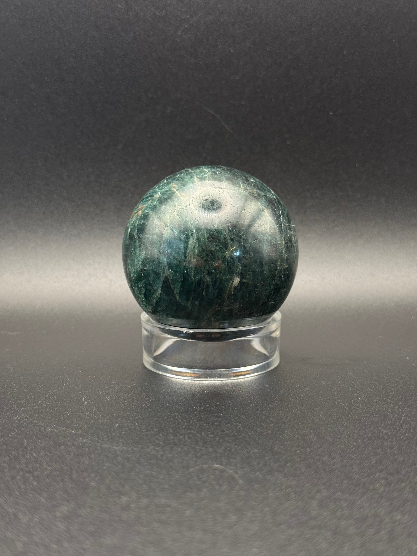 Polished green apatite crystal in the shape of a sphere.
