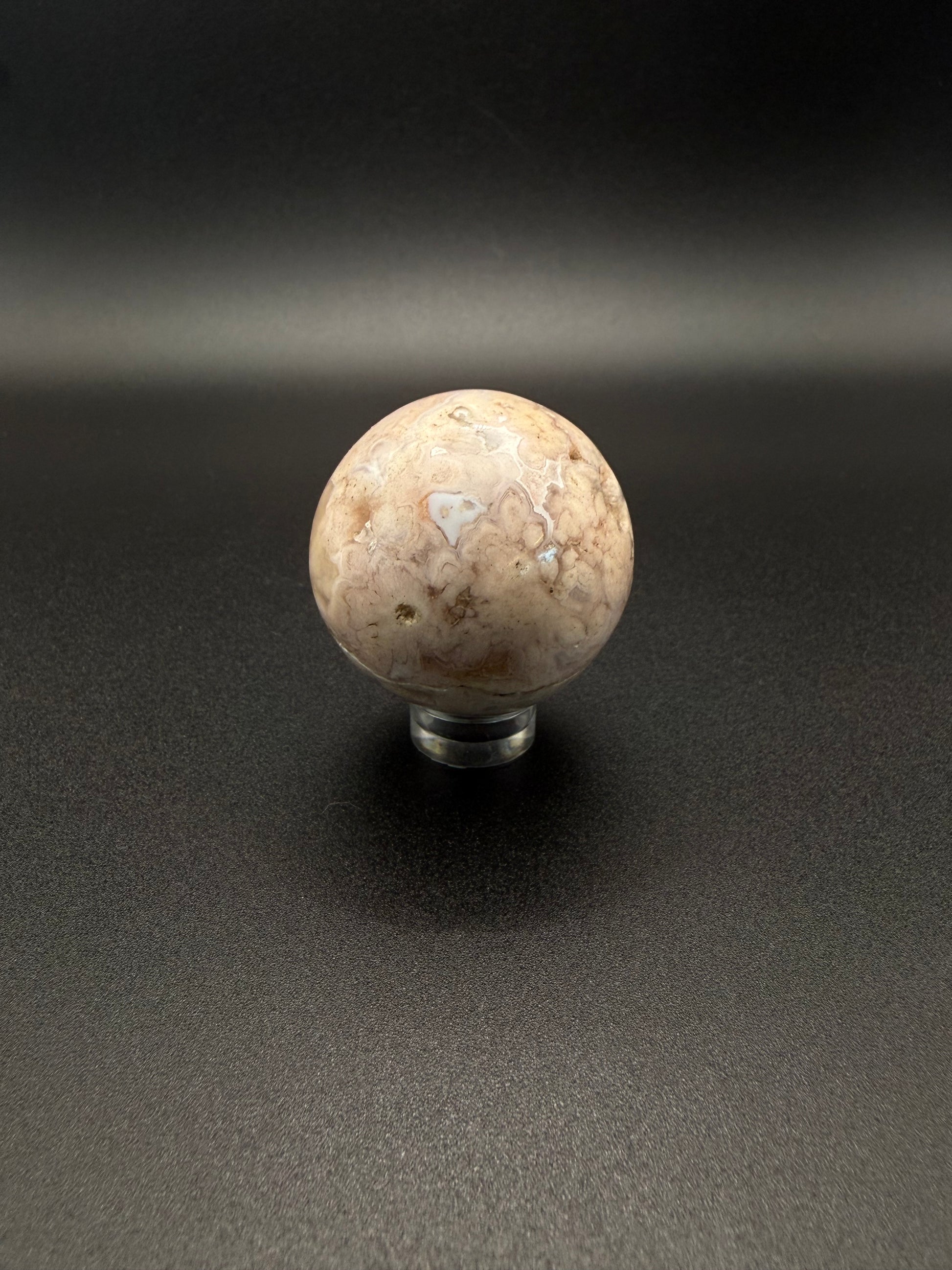 Flower agate polished crystal in the shape of a sphere.