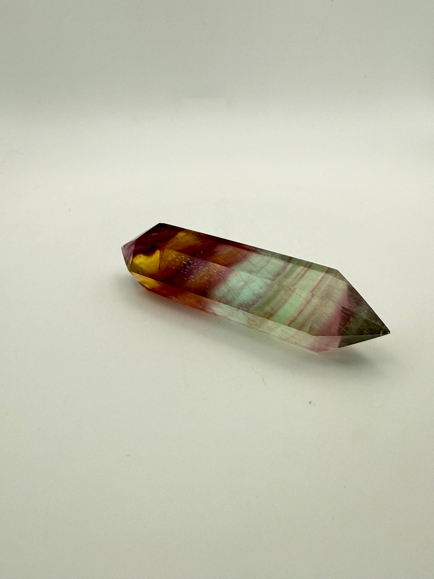 Rainbow Fluorite polished crystal in the shape of a double term.