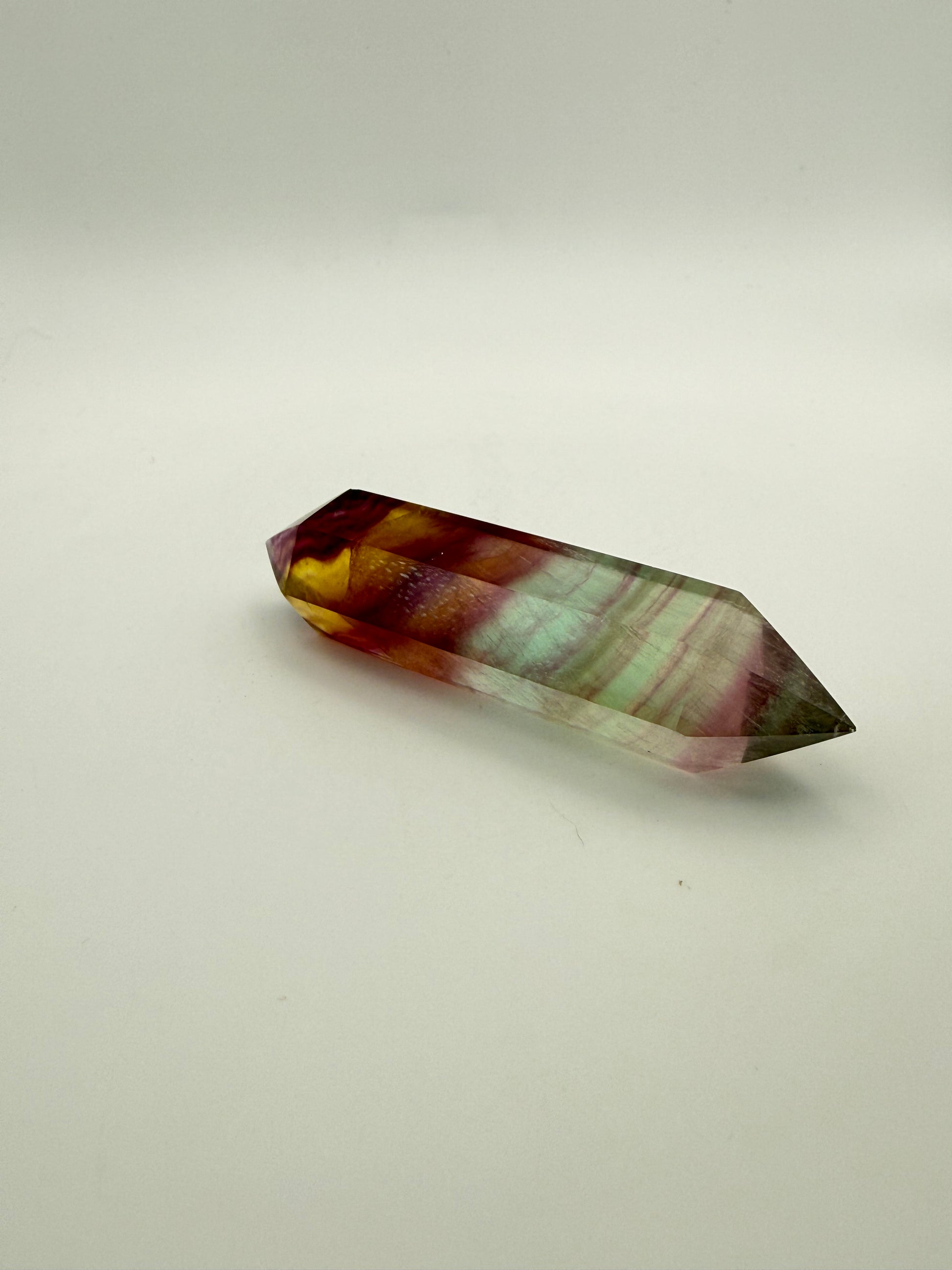 Rainbow Fluorite polished crystal in the shape of a double term.