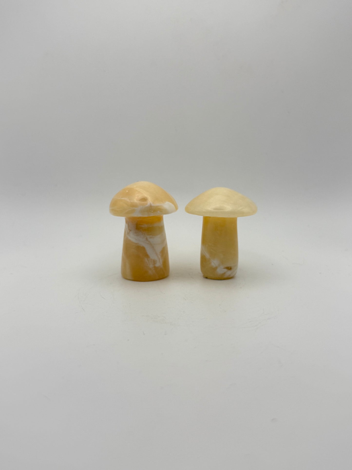 Two orange calcite mushrooms.