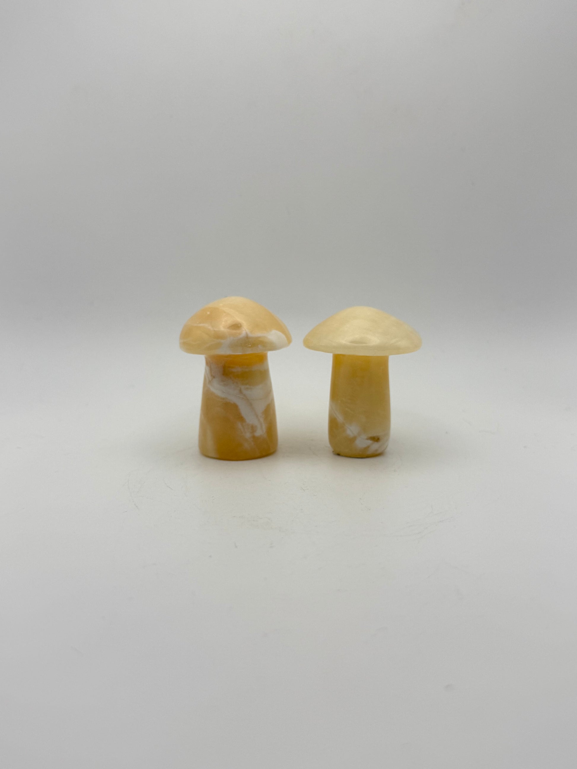 Two orange calcite mushrooms.