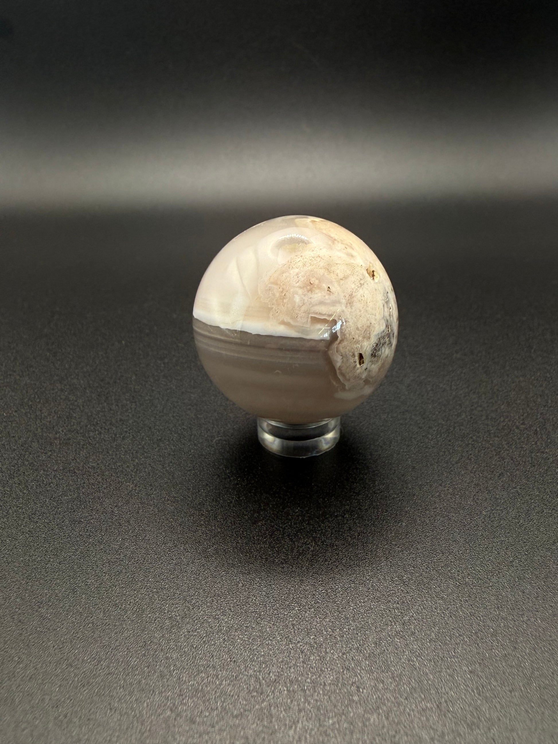 Flower agate polished crystal in the shape of a sphere.