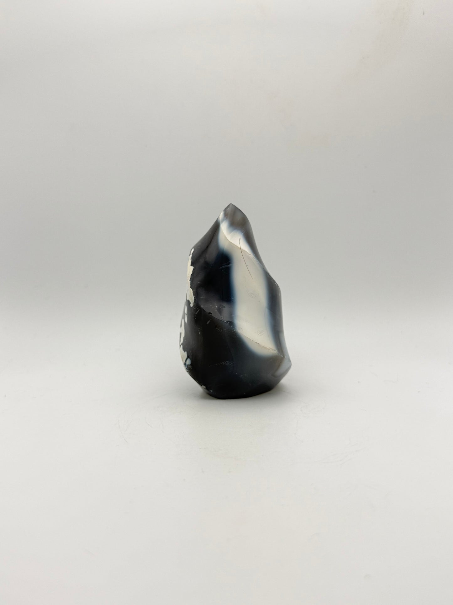 Polished orca agate in the shape of a flame.