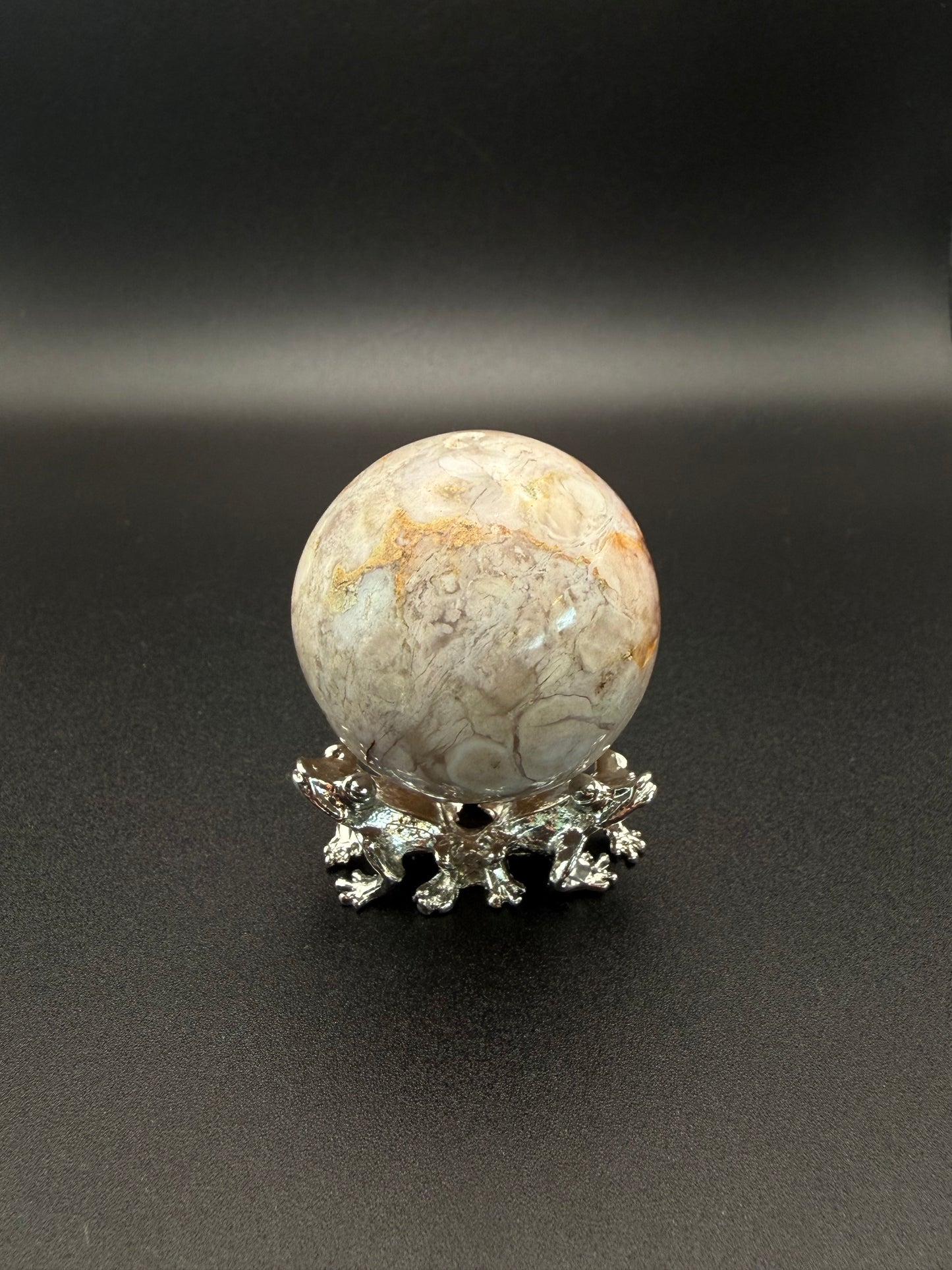 Flower agate polished crystal in the shape of a sphere.