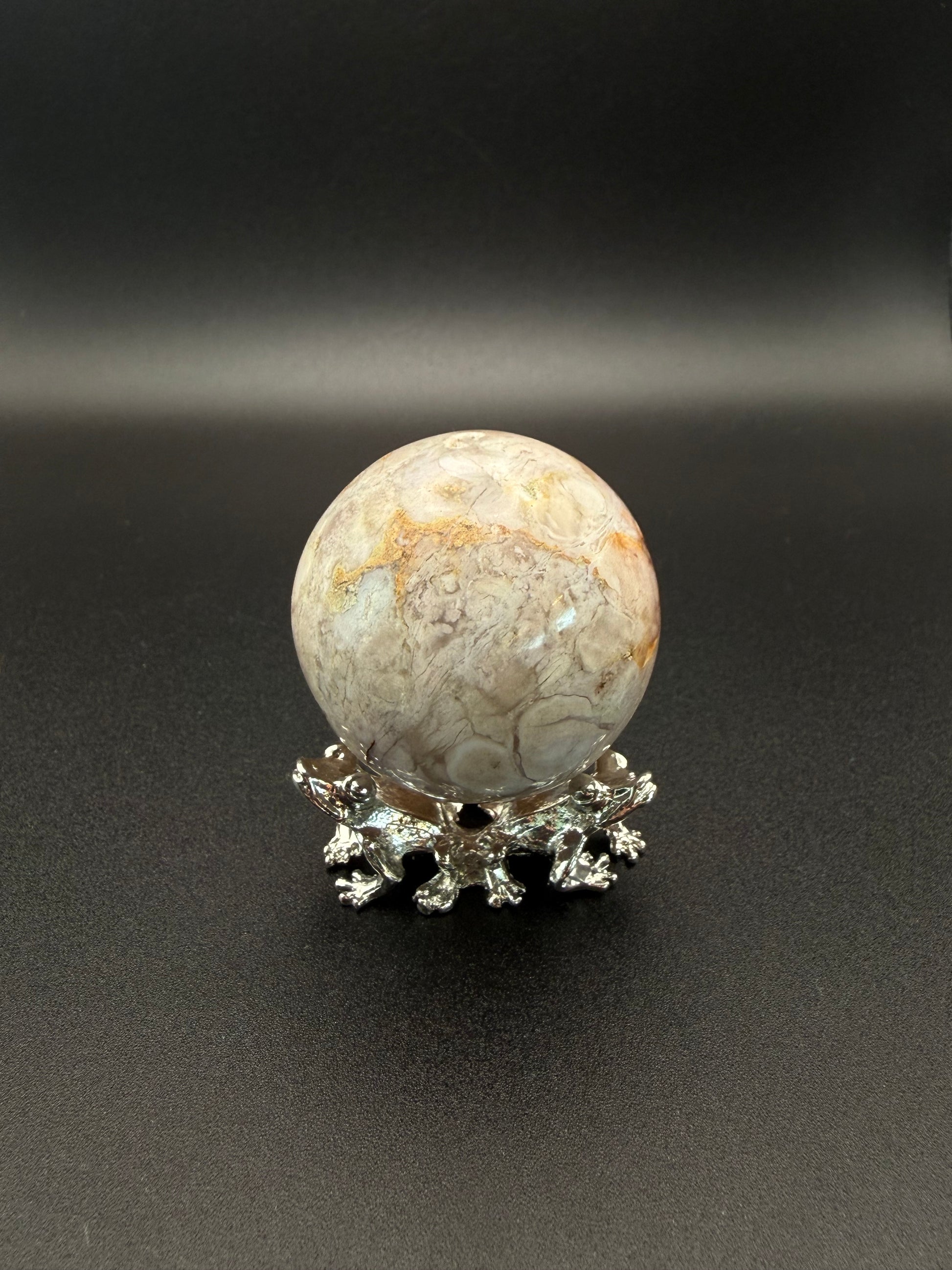 Flower agate polished crystal in the shape of a sphere.