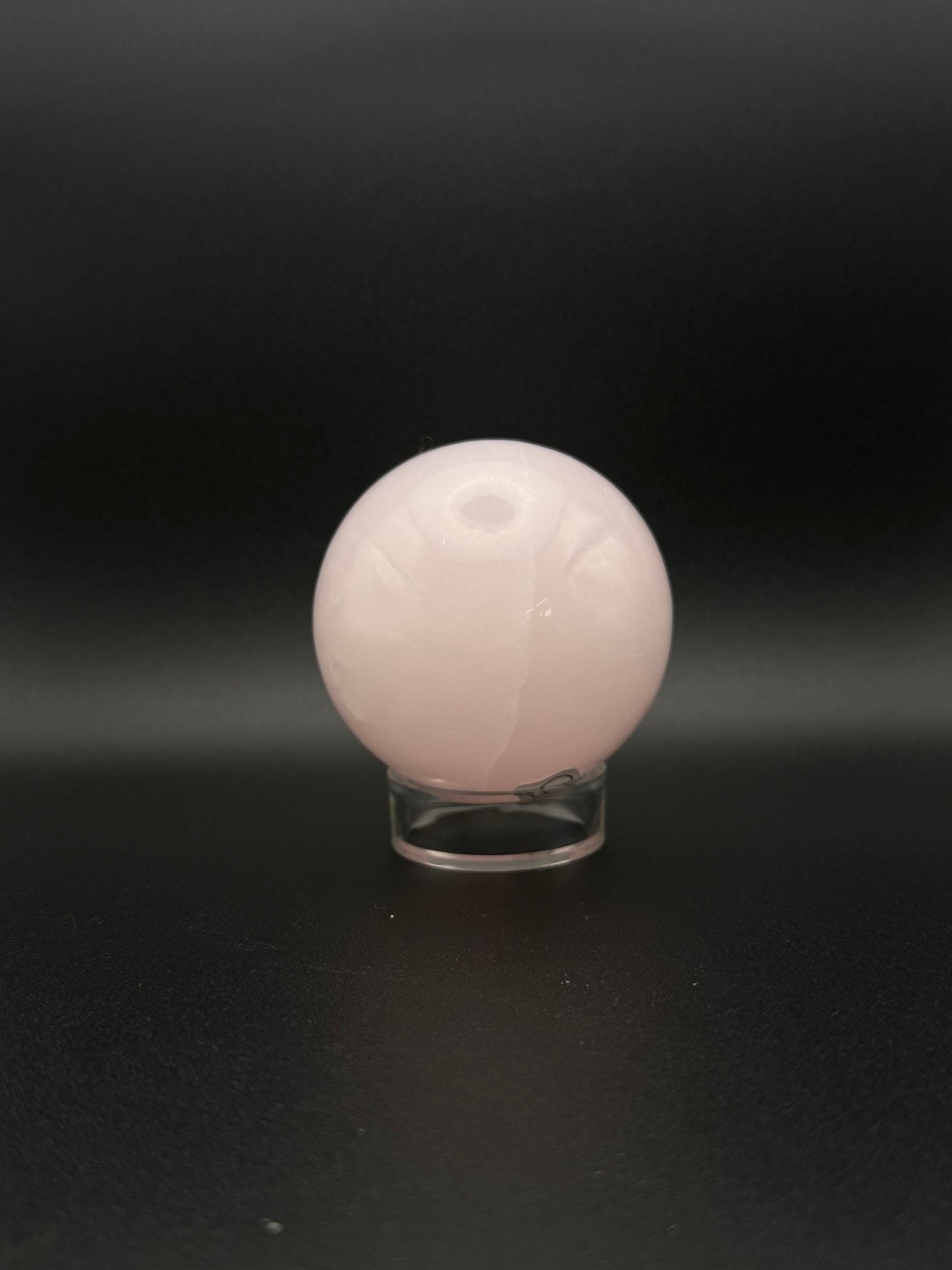 Polished pink calcite sphere. Pink calcite glows under uv light.