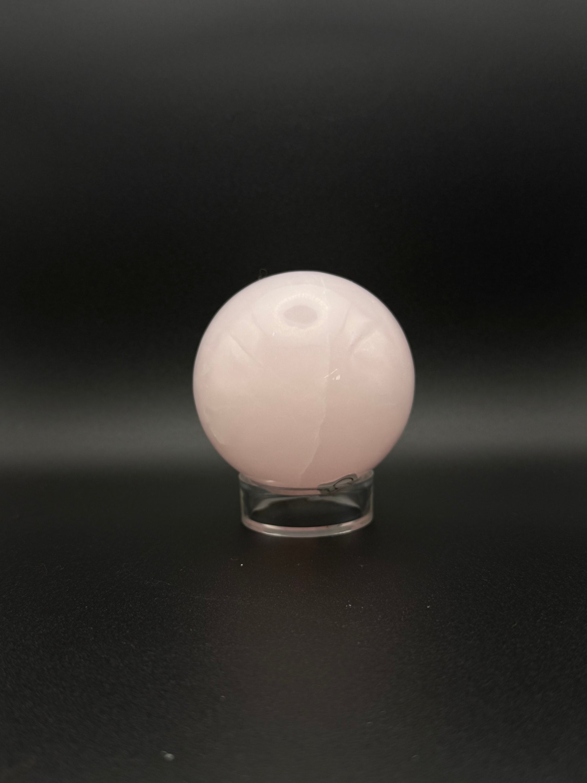 Polished pink calcite sphere. Pink calcite glows under uv light.