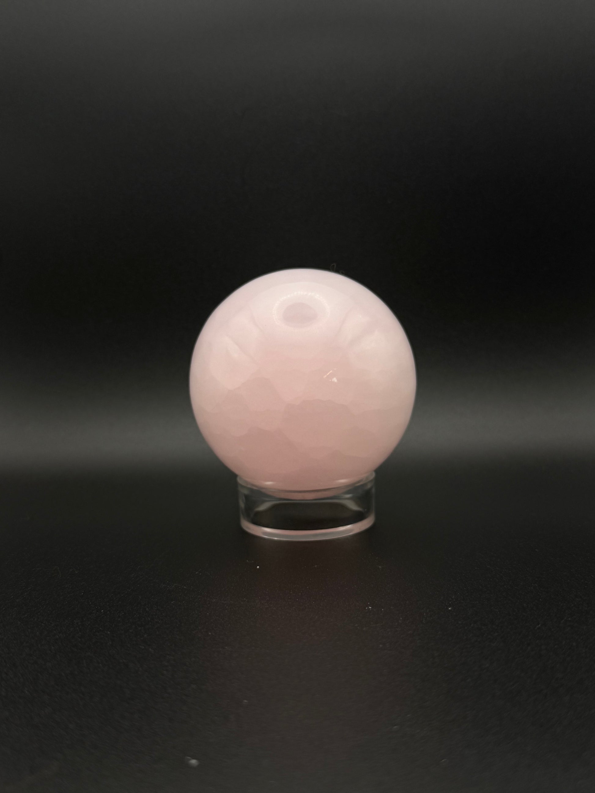 Polished pink calcite sphere. Pink calcite glows under uv light.