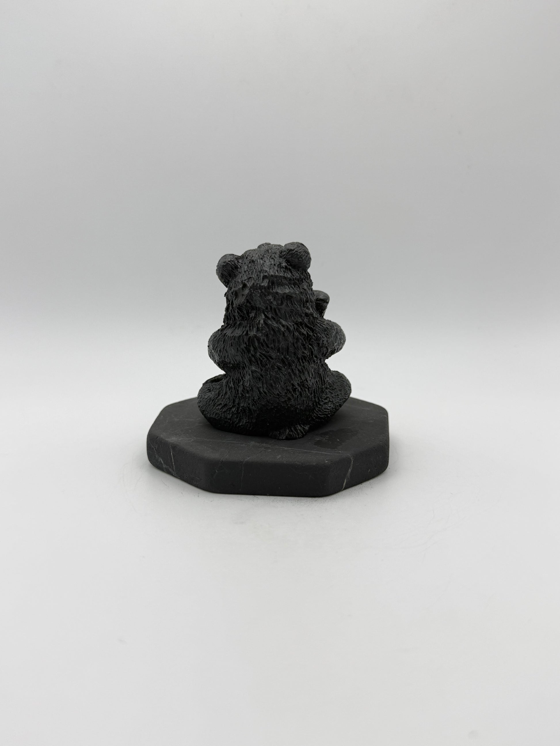 Shungite carving of a bear holding a fish.
