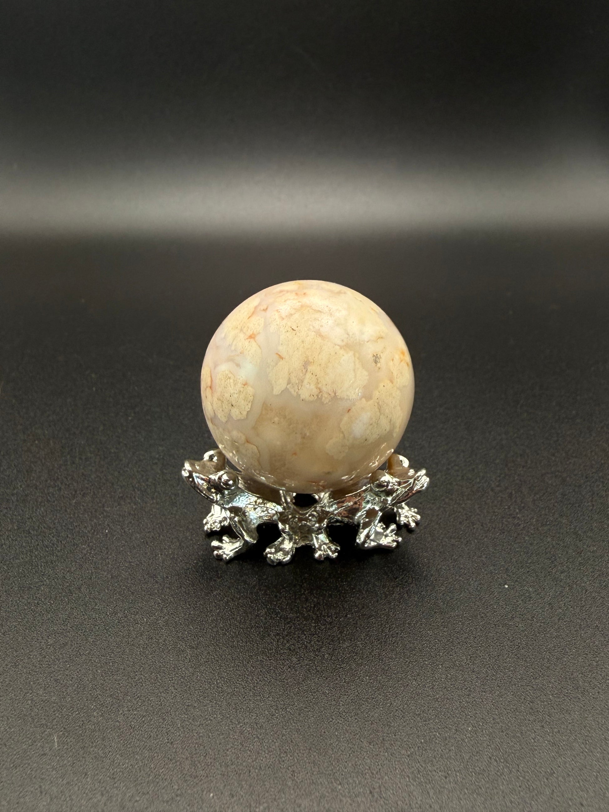 Flower agate polished crystal in the shape of a sphere.