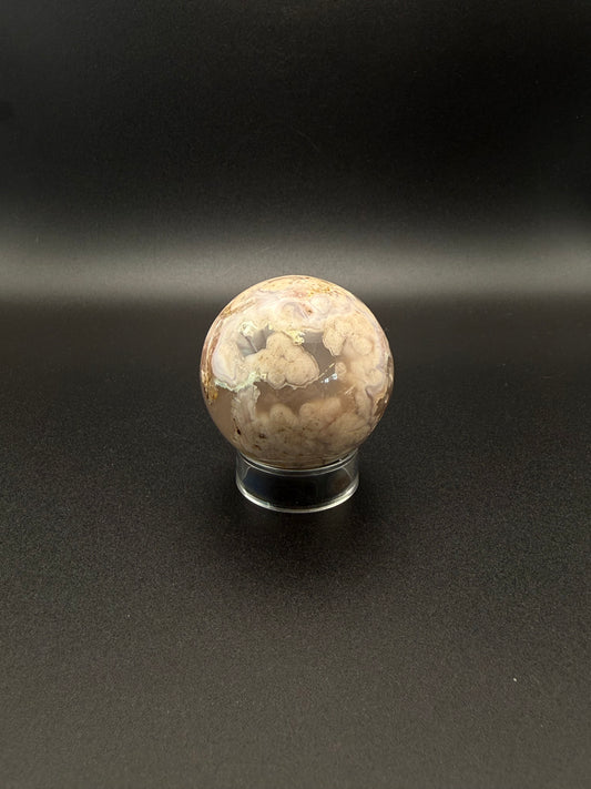 Flower agate polished crystal in the shape of a sphere.