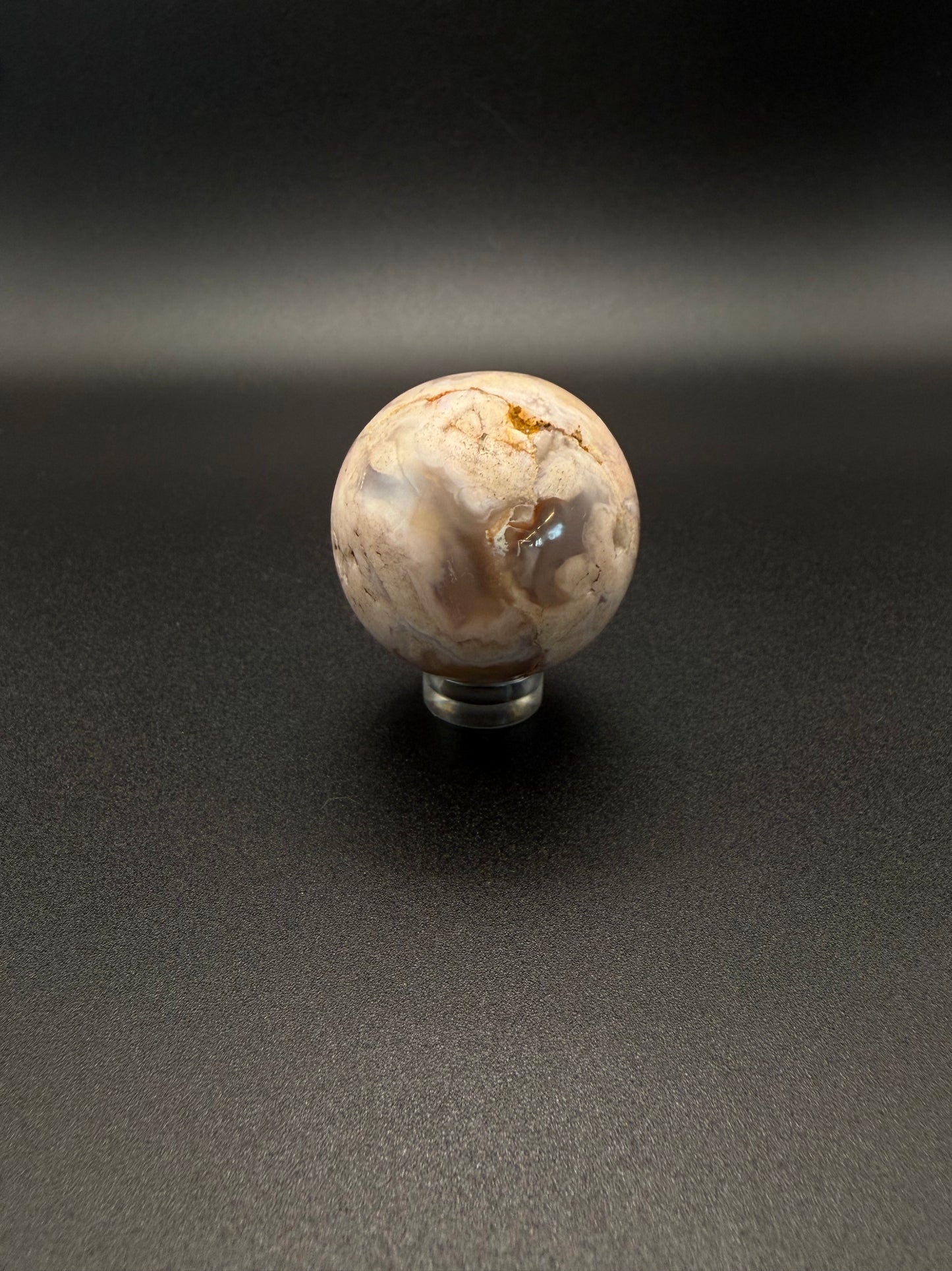 Flower agate polished crystal in the shape of a sphere.