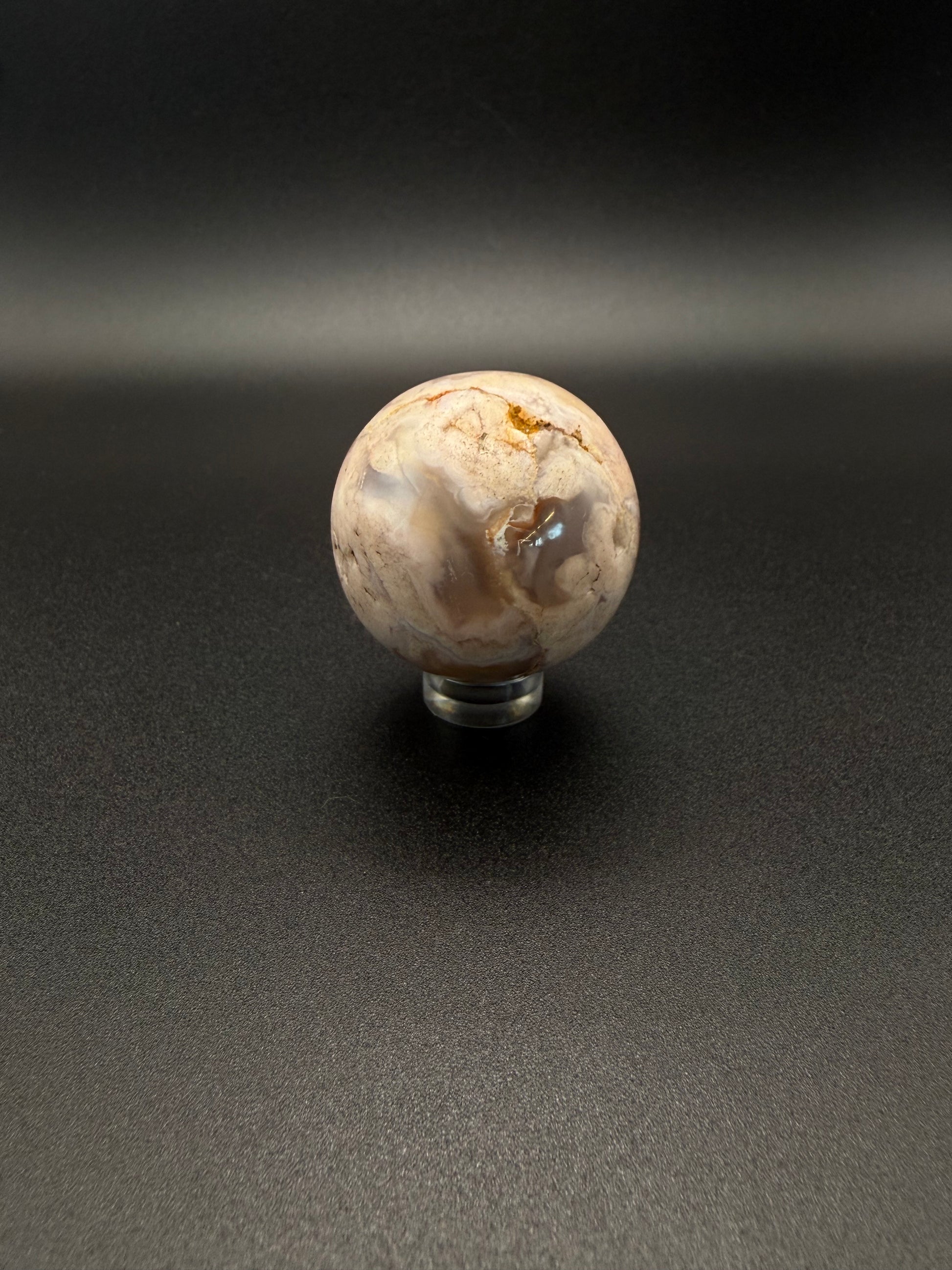 Flower agate polished crystal in the shape of a sphere.