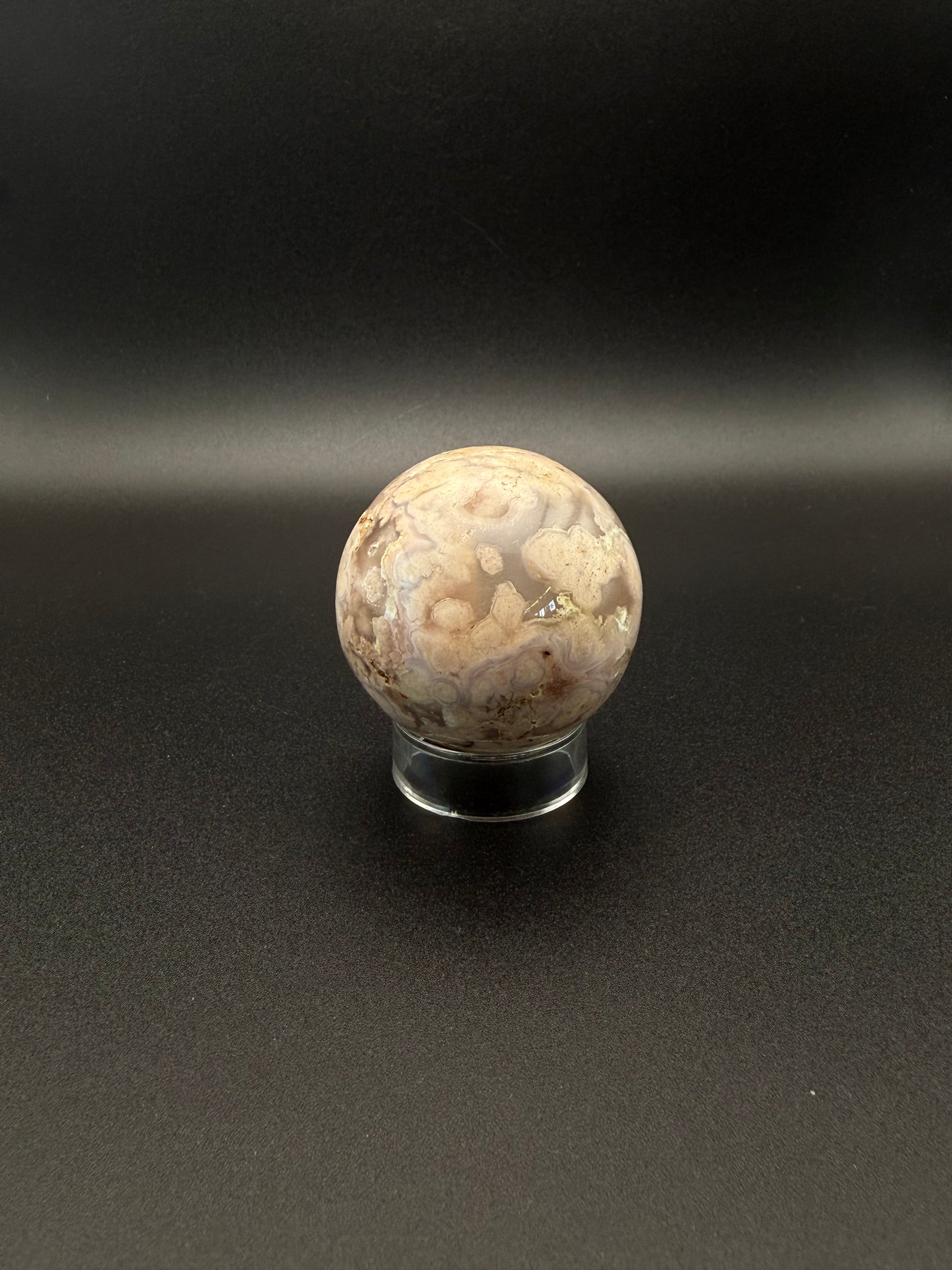 Flower agate polished crystal in the shape of a sphere.