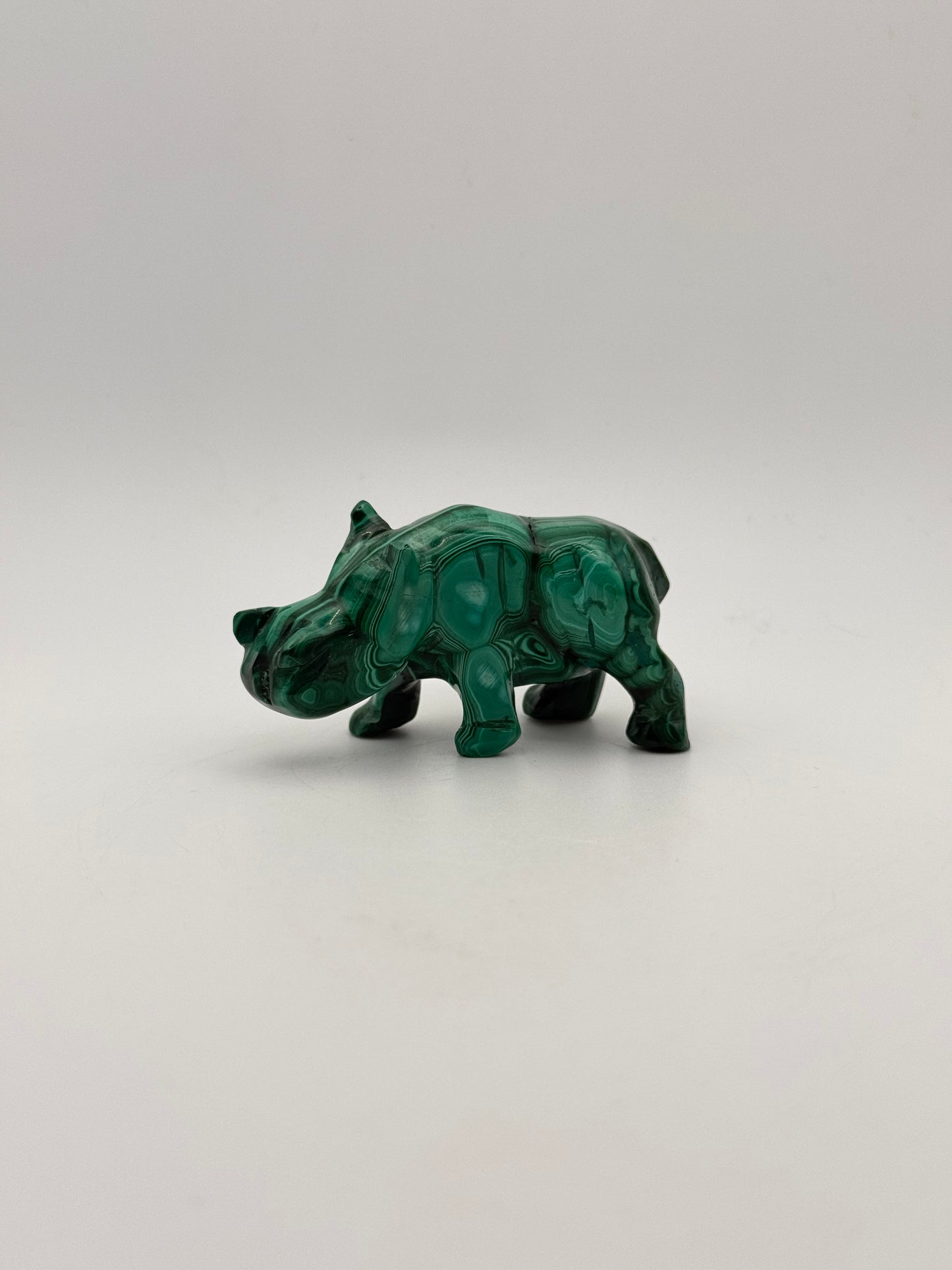 Vibrant green malachite stone carving of a rhino.