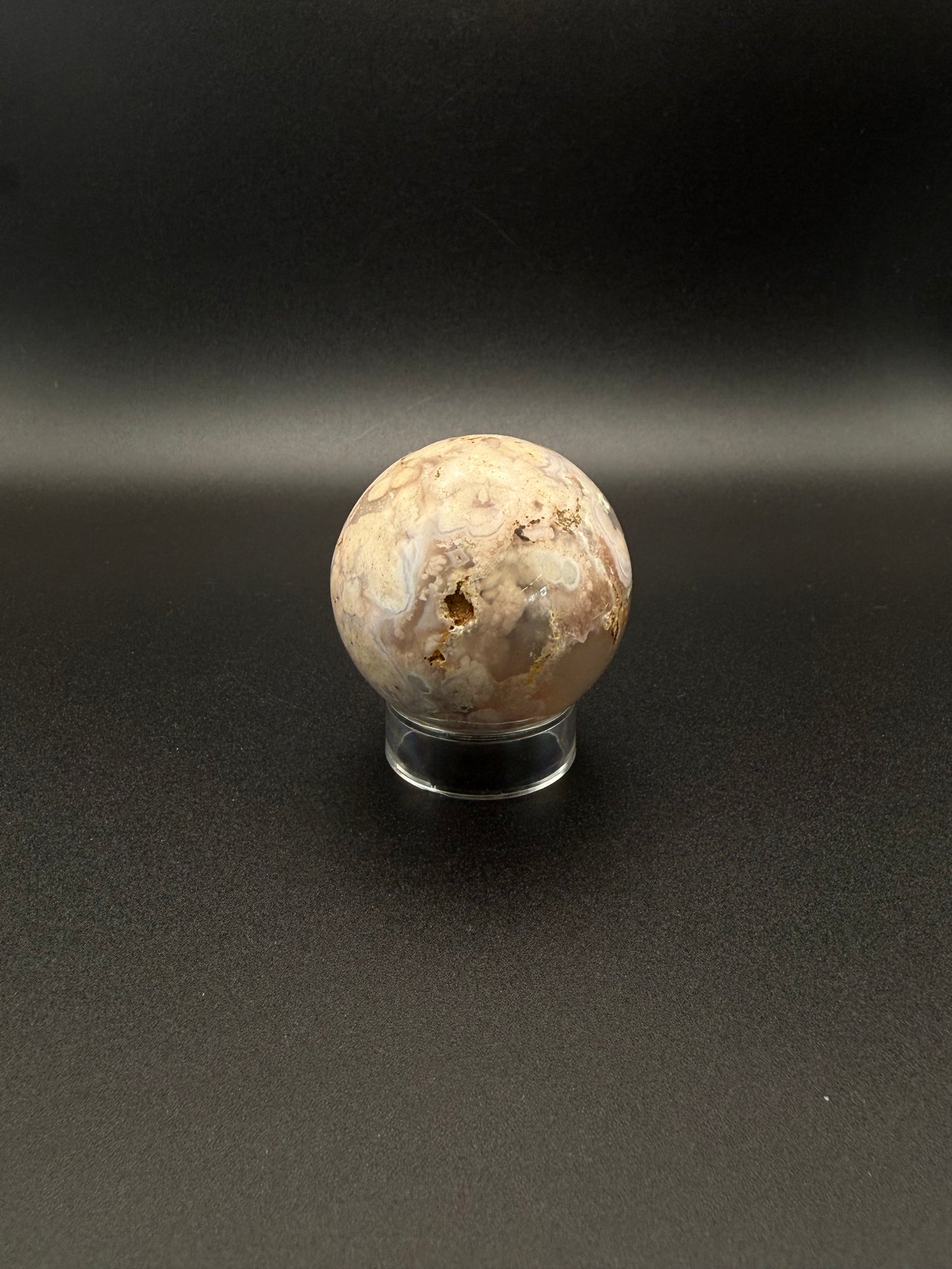 Flower agate polished crystal in the shape of a sphere.