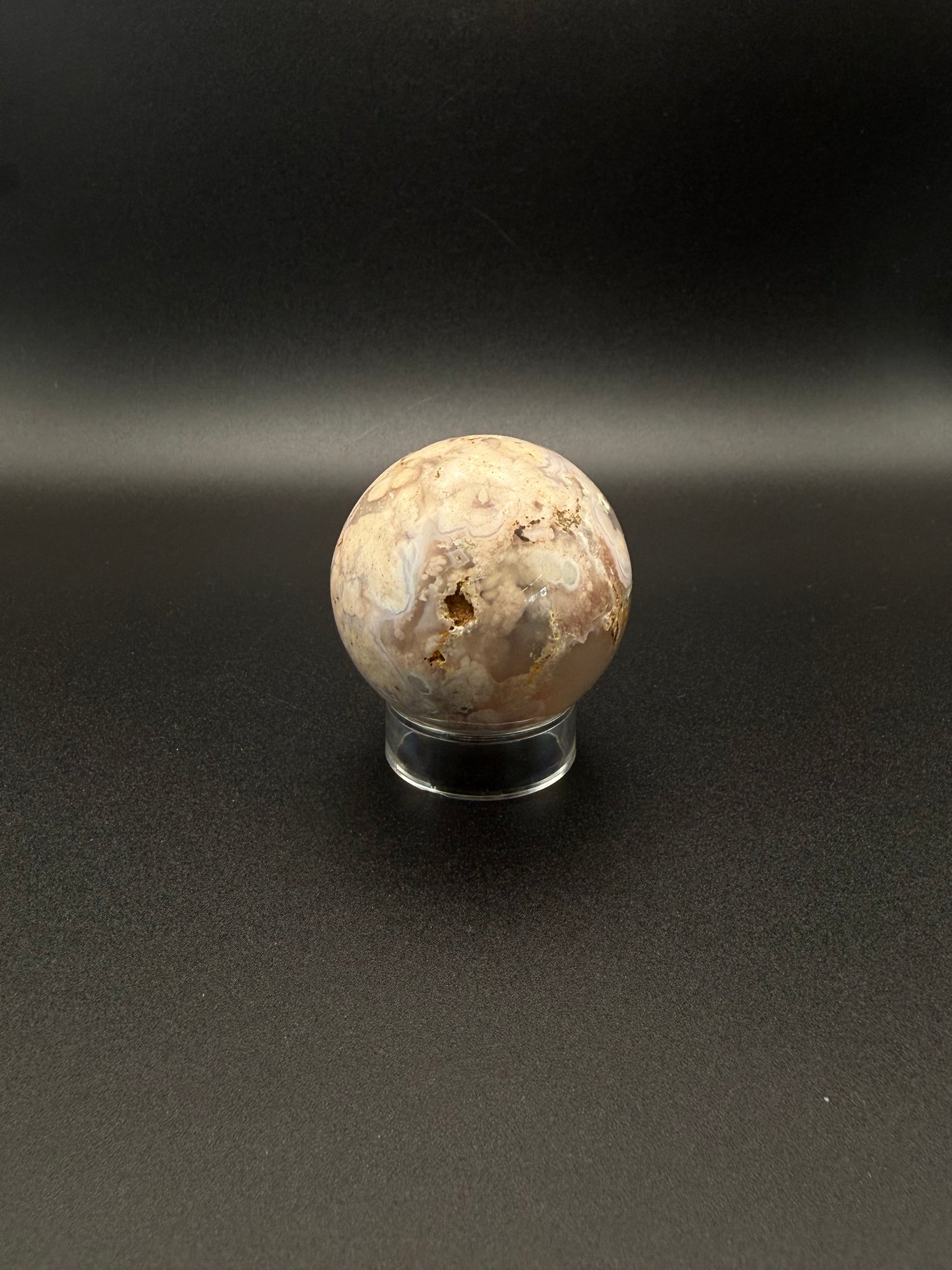 Flower agate polished crystal in the shape of a sphere.