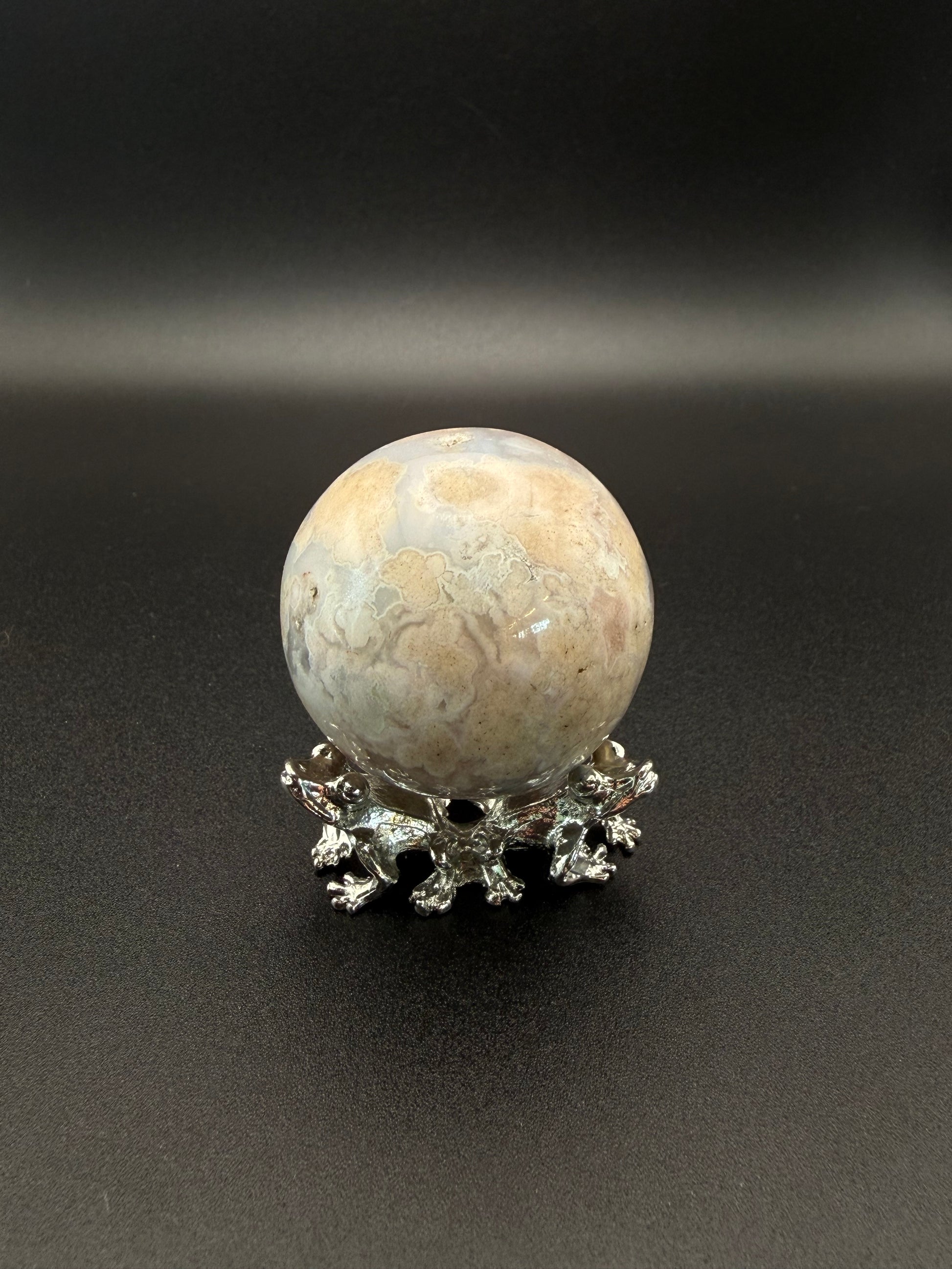 Flower agate polished crystal in the shape of a sphere.