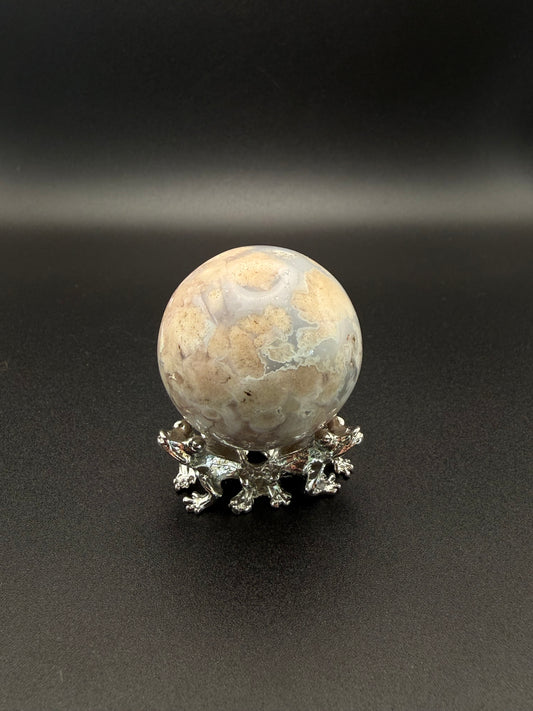 Flower agate polished crystal in the shape of a sphere.