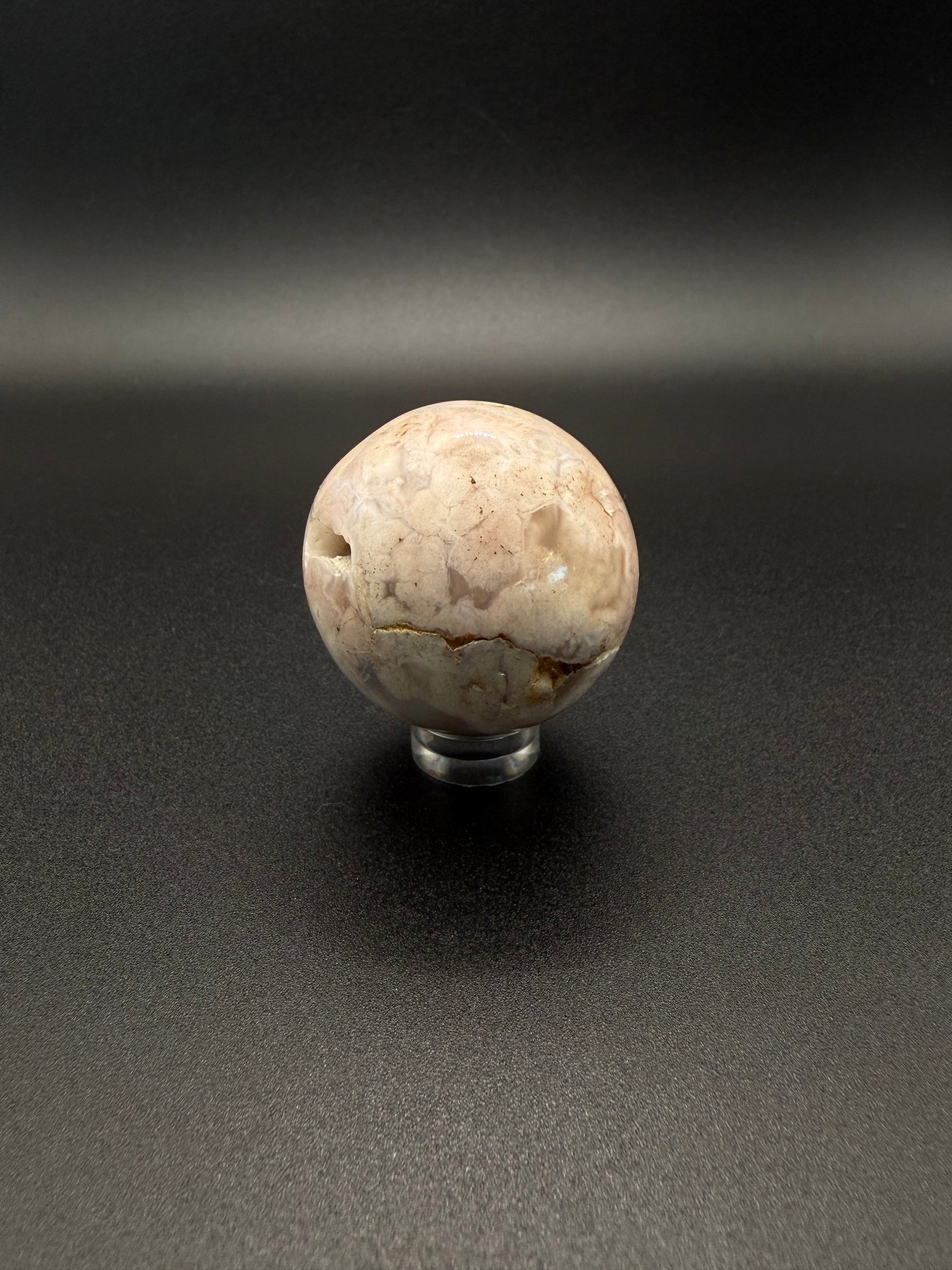 Flower agate polished crystal in the shape of a sphere.