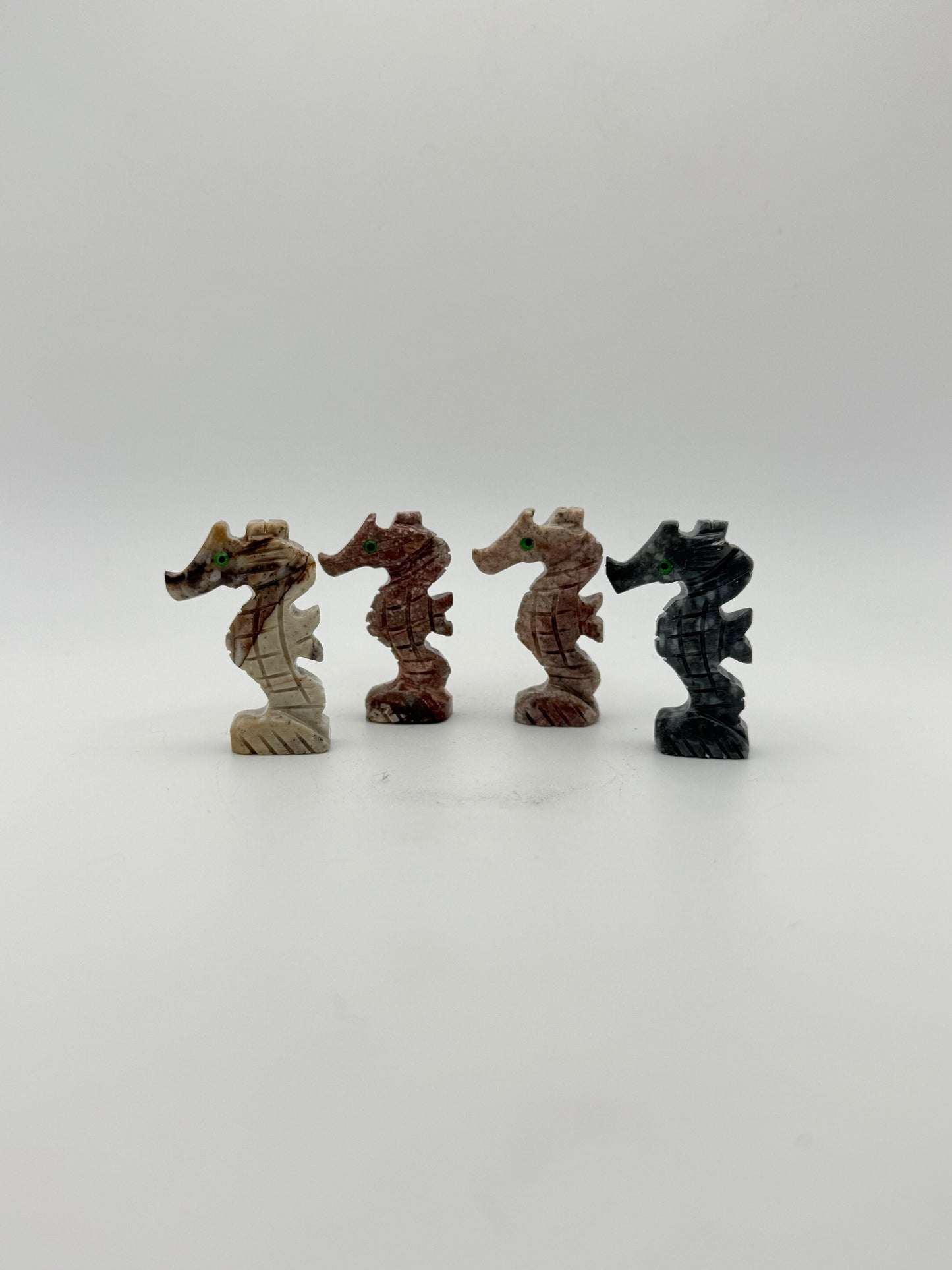 Small stone sculptures of animals arranged vertically on a white background
