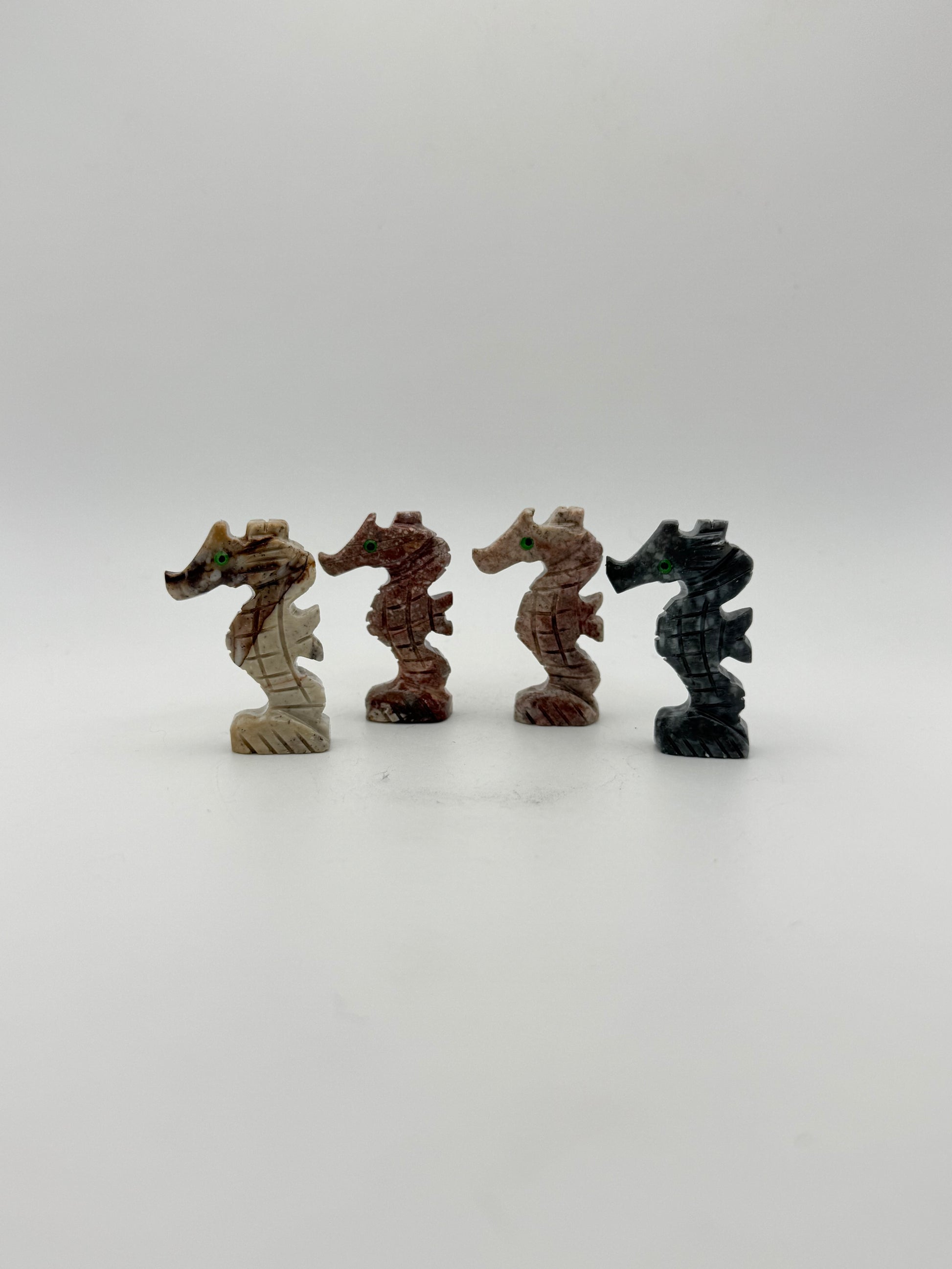Small stone sculptures of animals arranged vertically on a white background