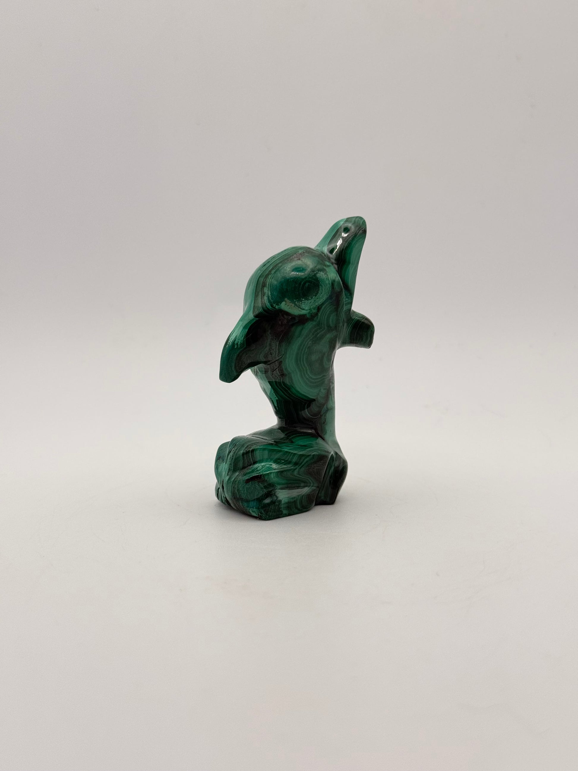 Polished malachite dolphin carving.