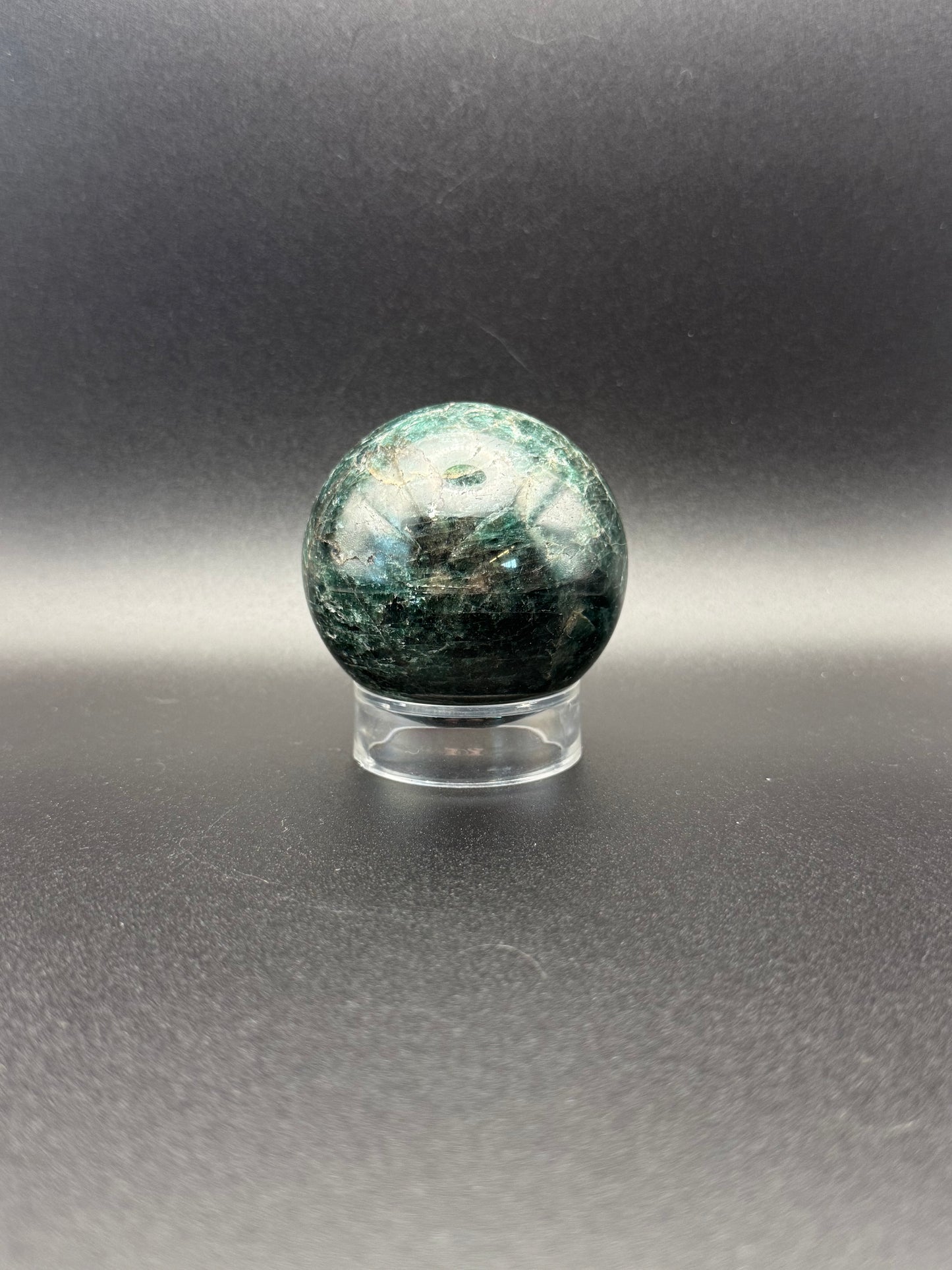 Polished green apatite crystal in the shape of a sphere.