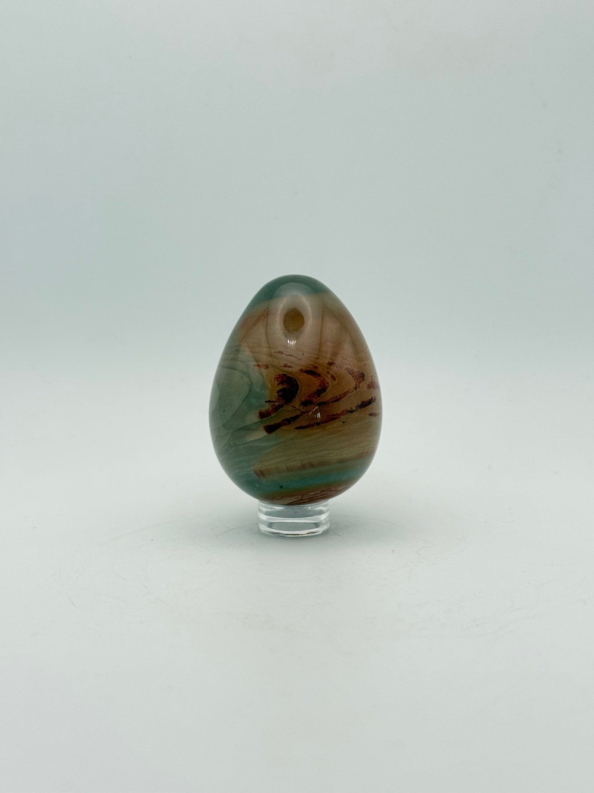 Polished polychrome jasper shaped into an egg.