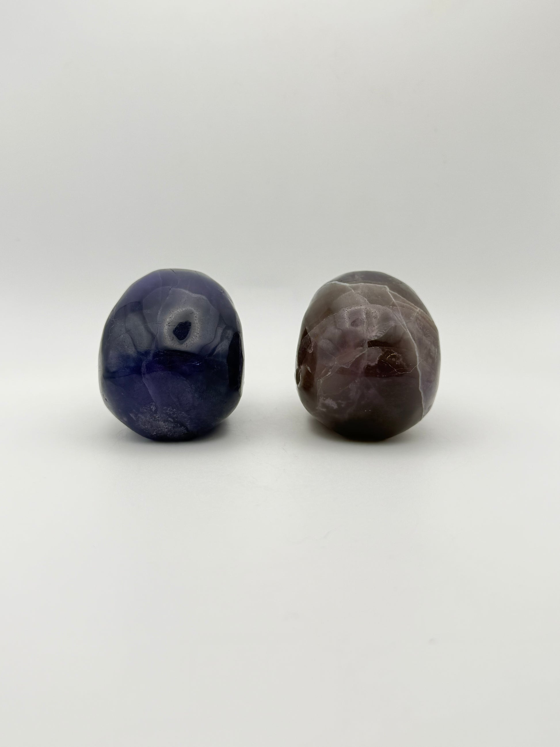 Two purple fluorite polished stone skulls.