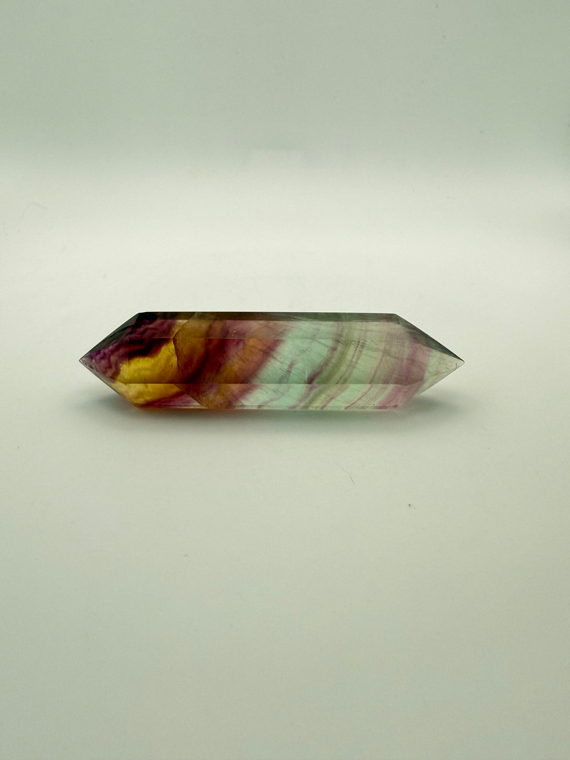 Rainbow Fluorite polished crystal in the shape of a double term.