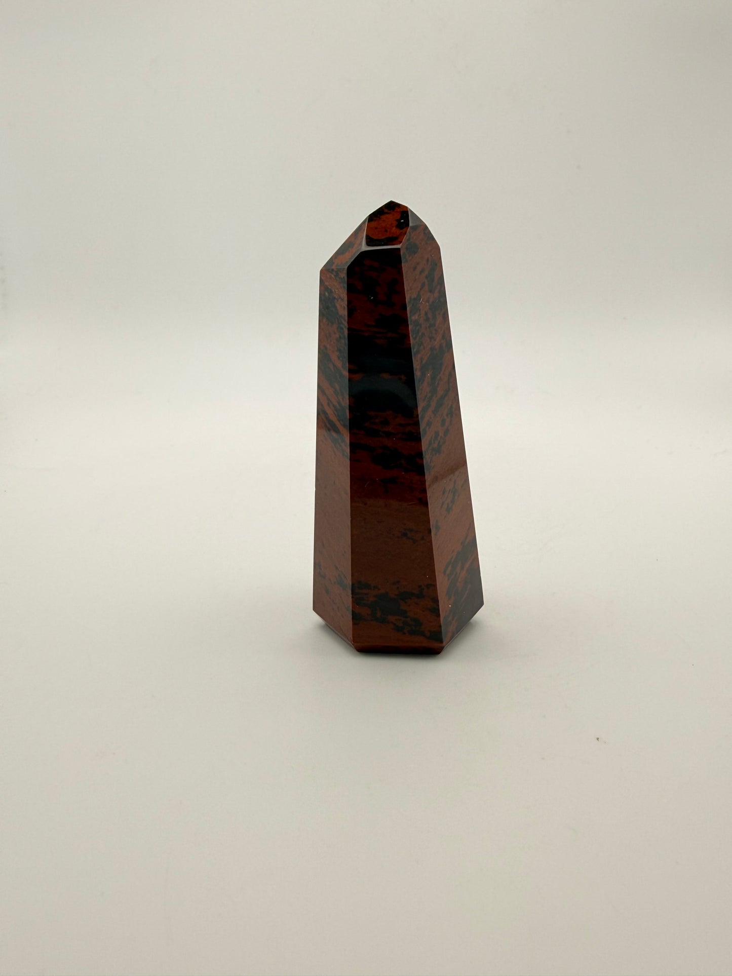 Polished mahogany obsidian tower with six sides.