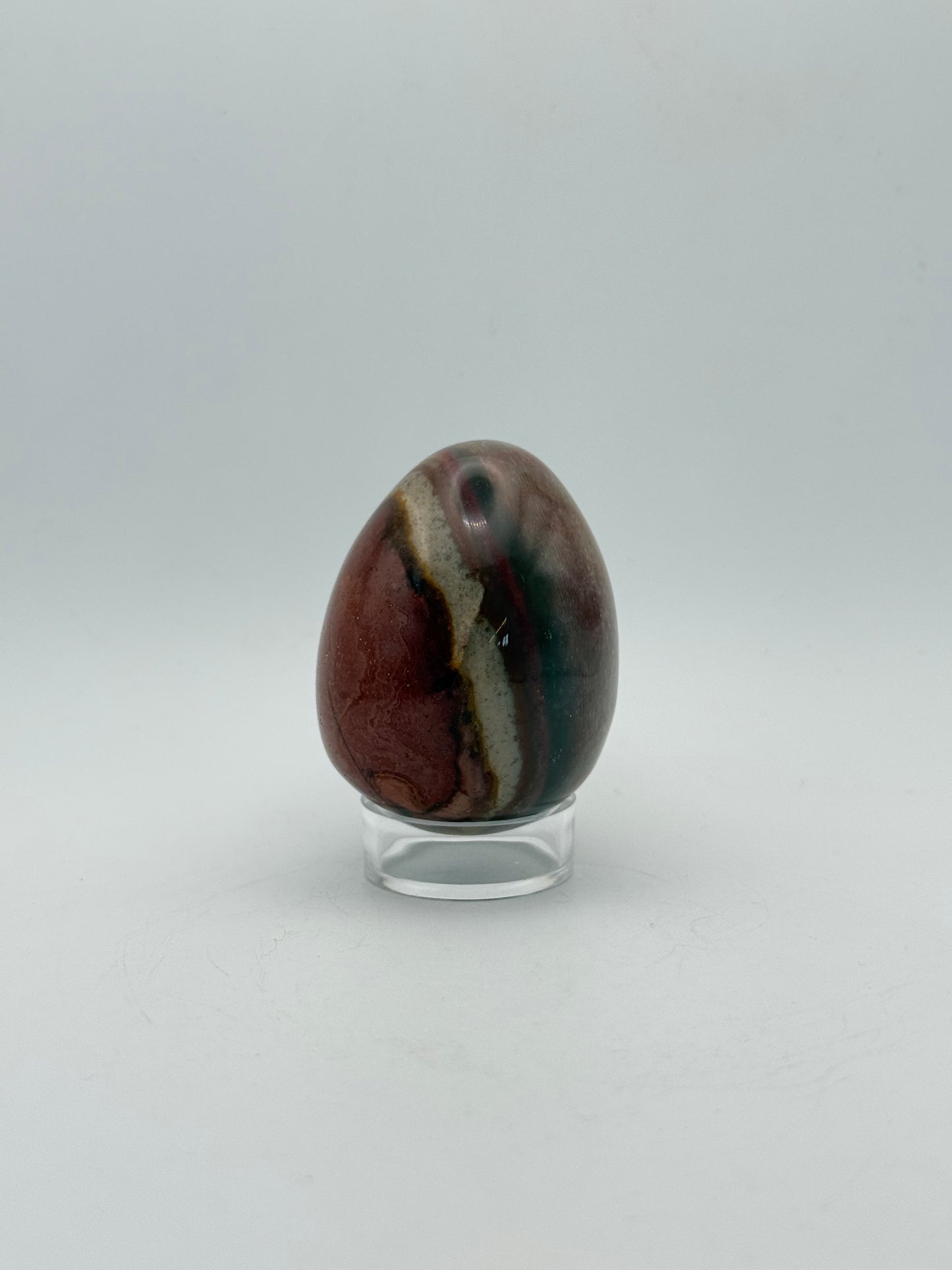 Polished polychrome jasper shaped into an egg.