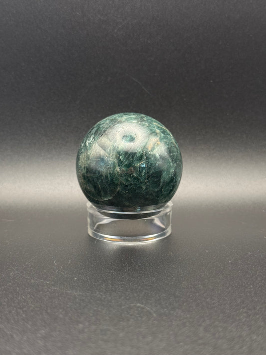 Polished green apatite crystal in the shape of a sphere.