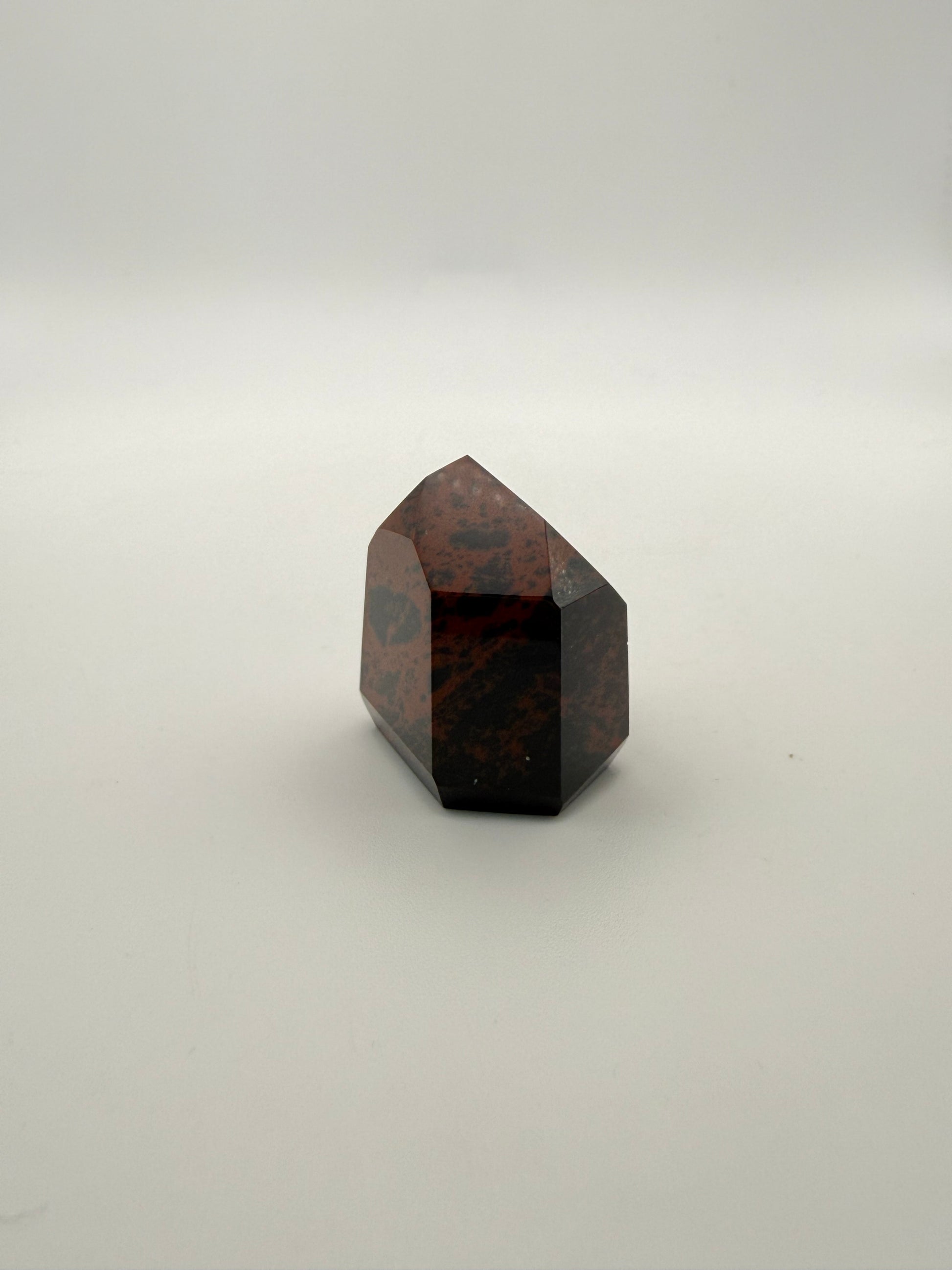 Polished mahogany obsidian tower with six sides.