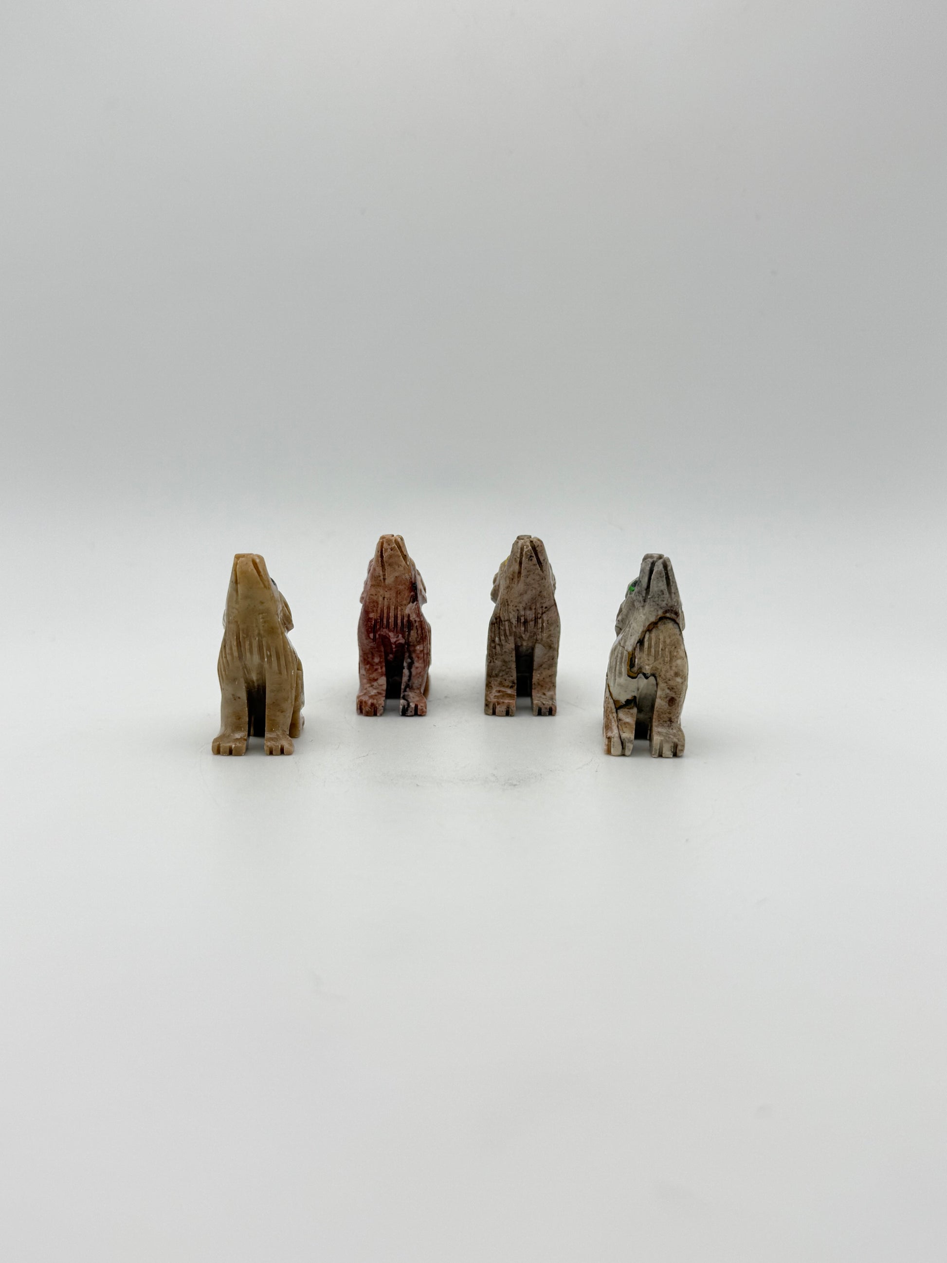 Small stone sculptures of animals arranged vertically on a white background