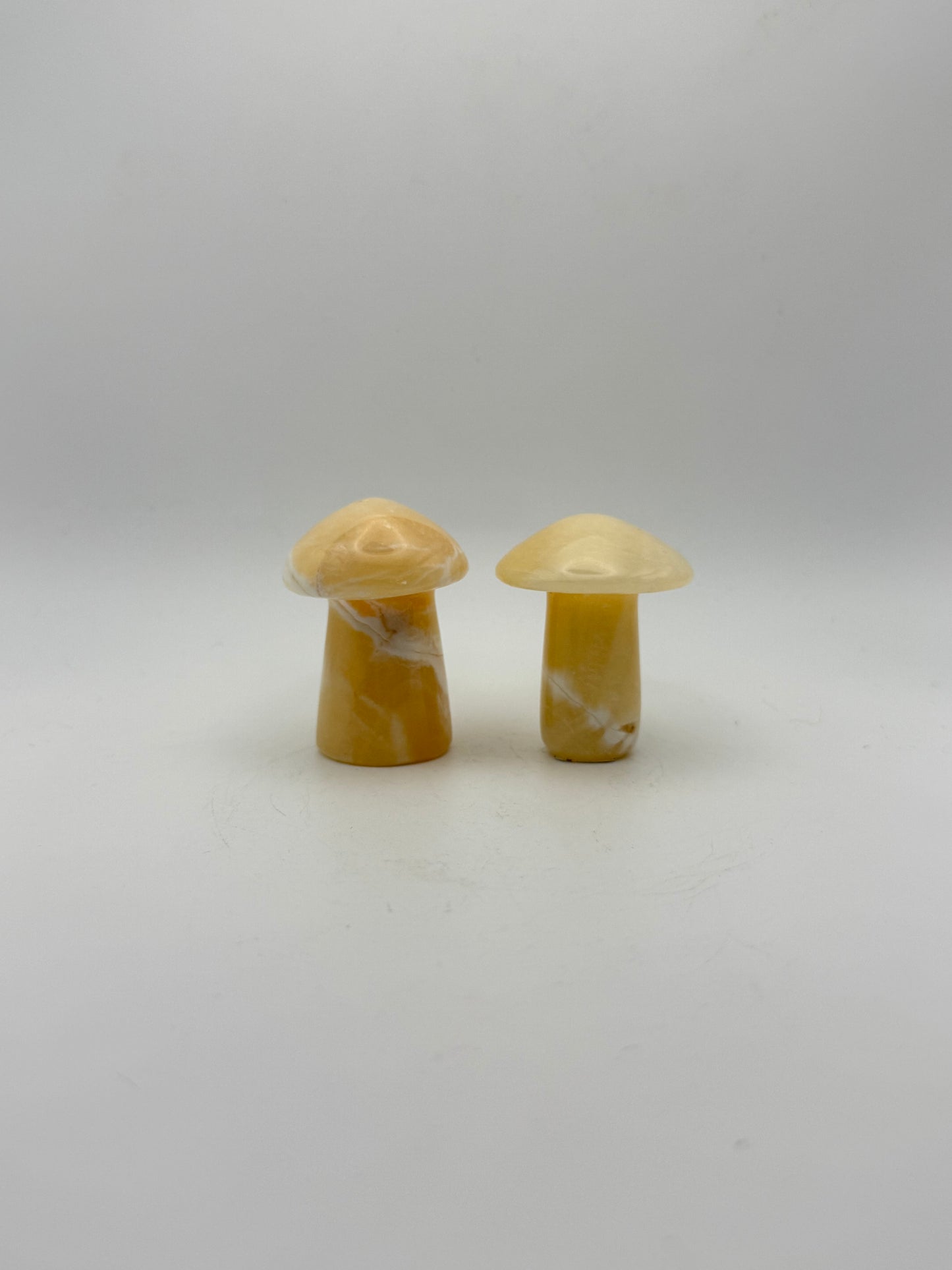 Two orange calcite mushrooms.