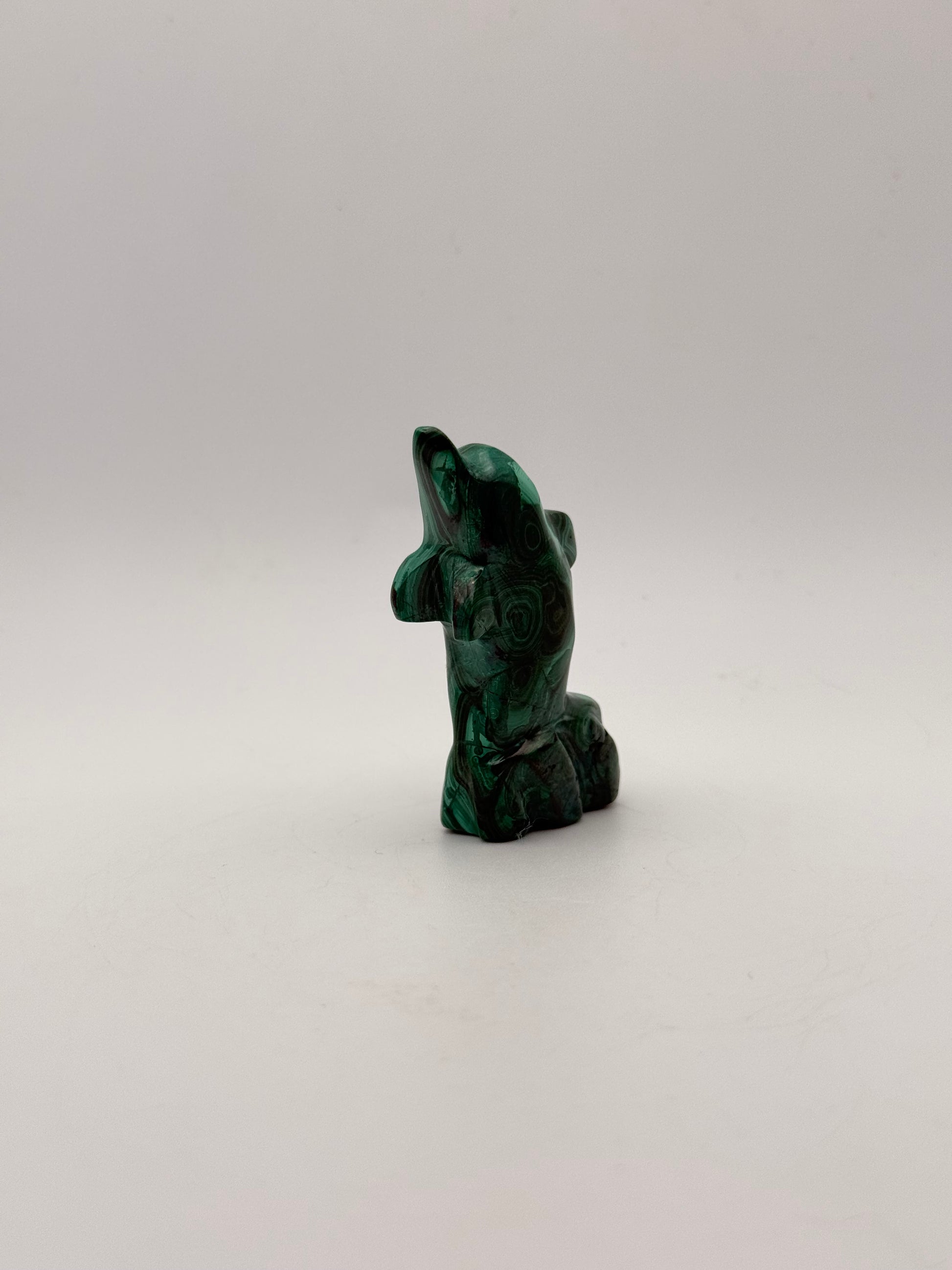 Polished malachite dolphin carving.